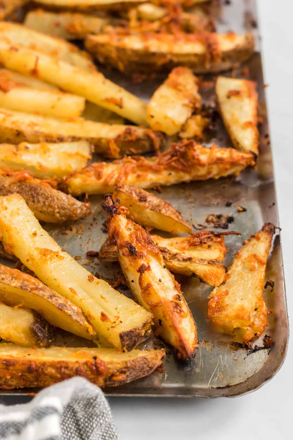 parmesan crusted crispy potato wedges on a baking sheet