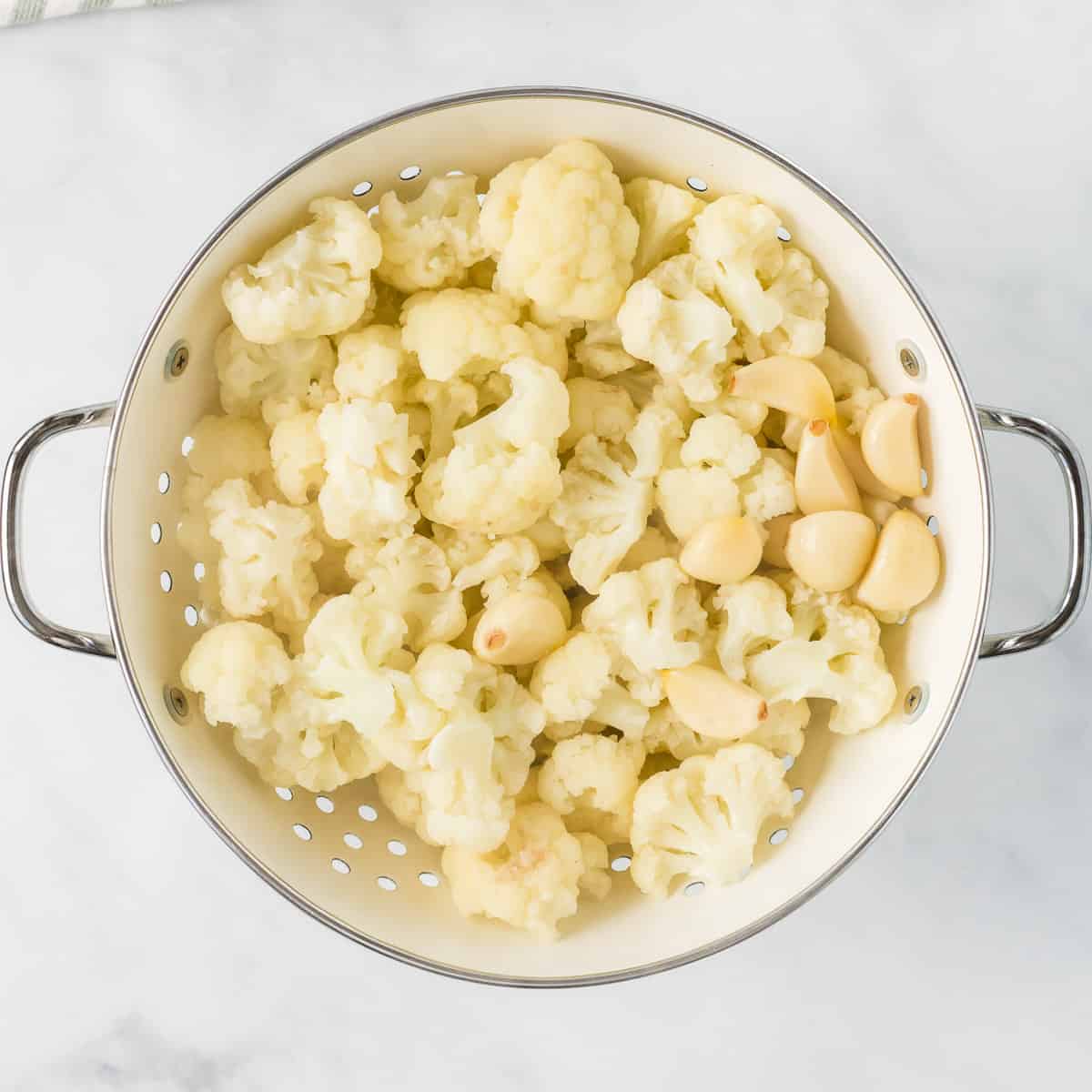 steamed cauliflower and garlic in a strainer