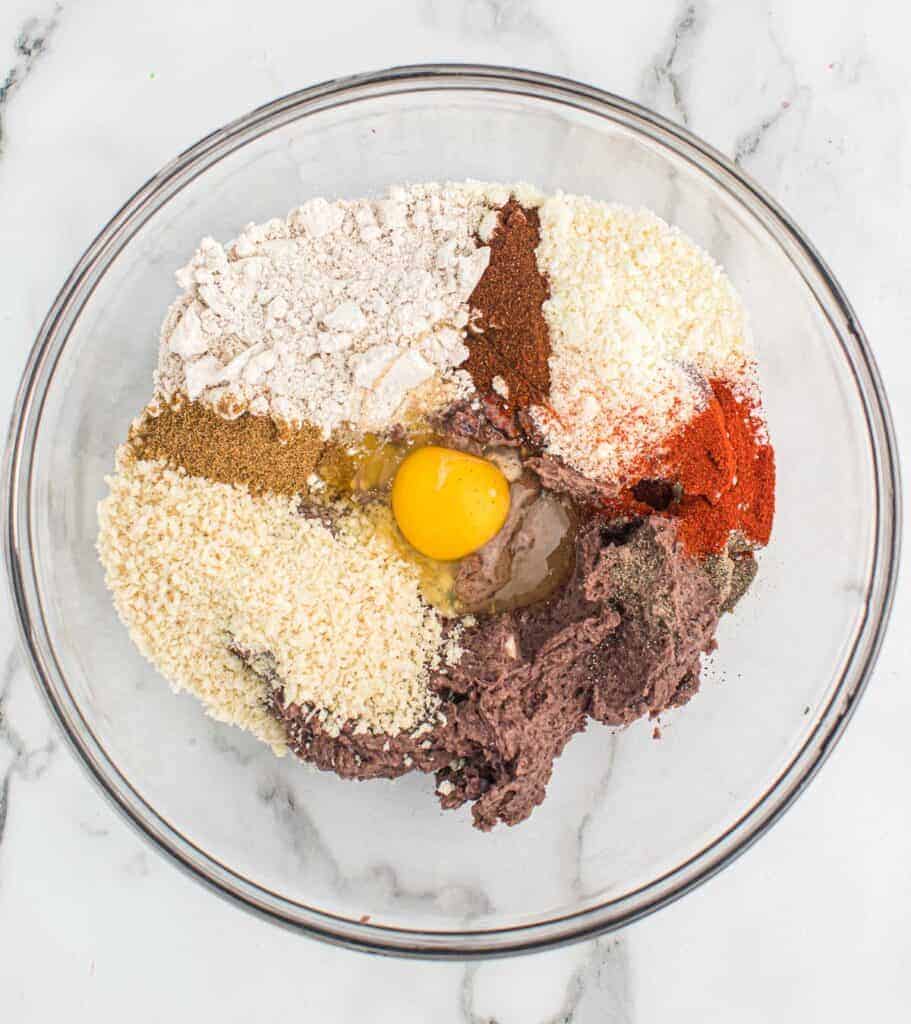 adding the black bean burger ingredients to a mixing bowl