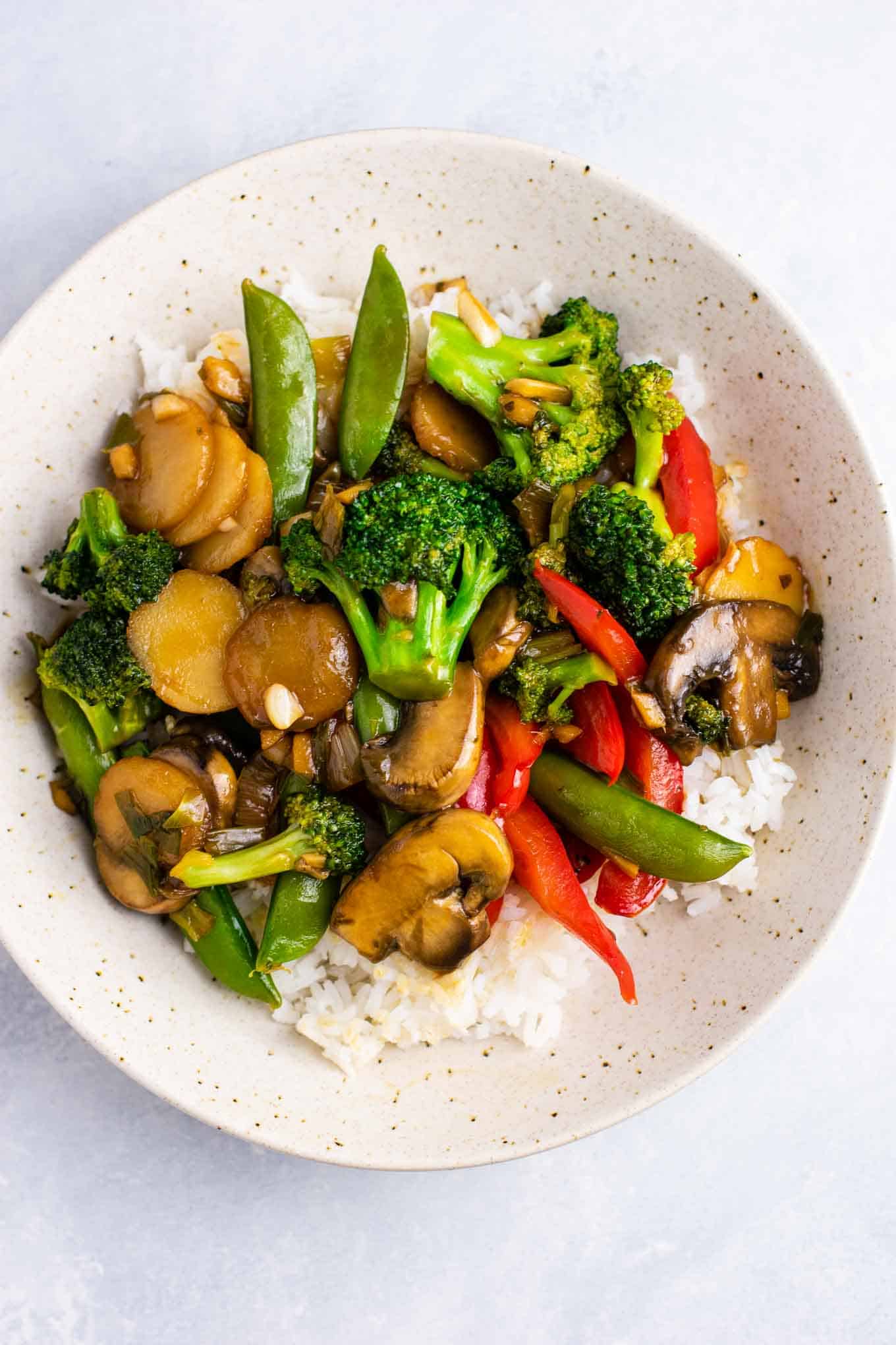 a bowl of stir fry vegetables over white rice