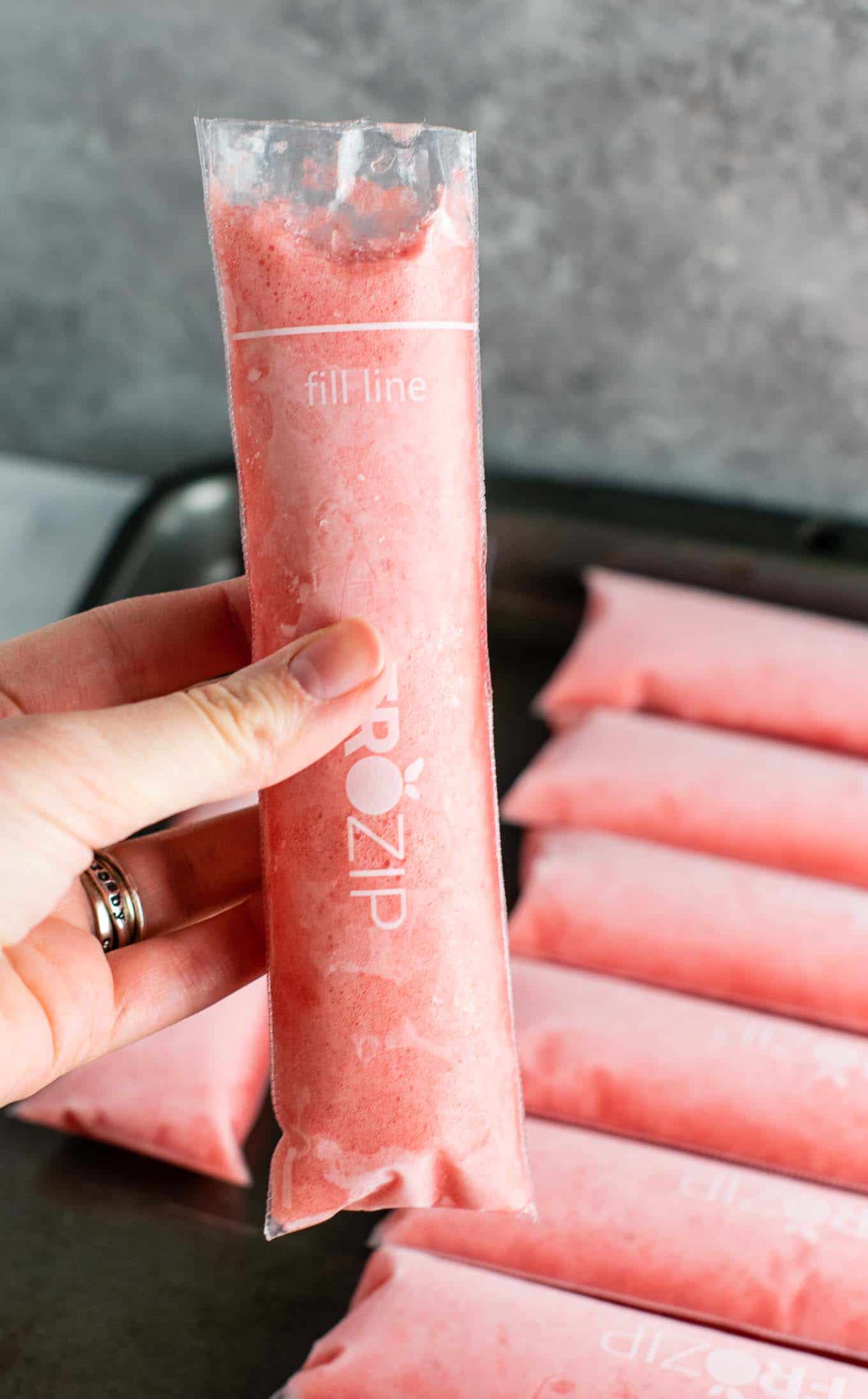 Strawberry pineapple freezer pops – learn how to make popsicles with just frozen fruit, coconut water and maple syrup! #freezerpops #healthy #icepops #popsicles #homemade #healthyrecipe #dessert #healthydessert #strawberrypineapple #summer