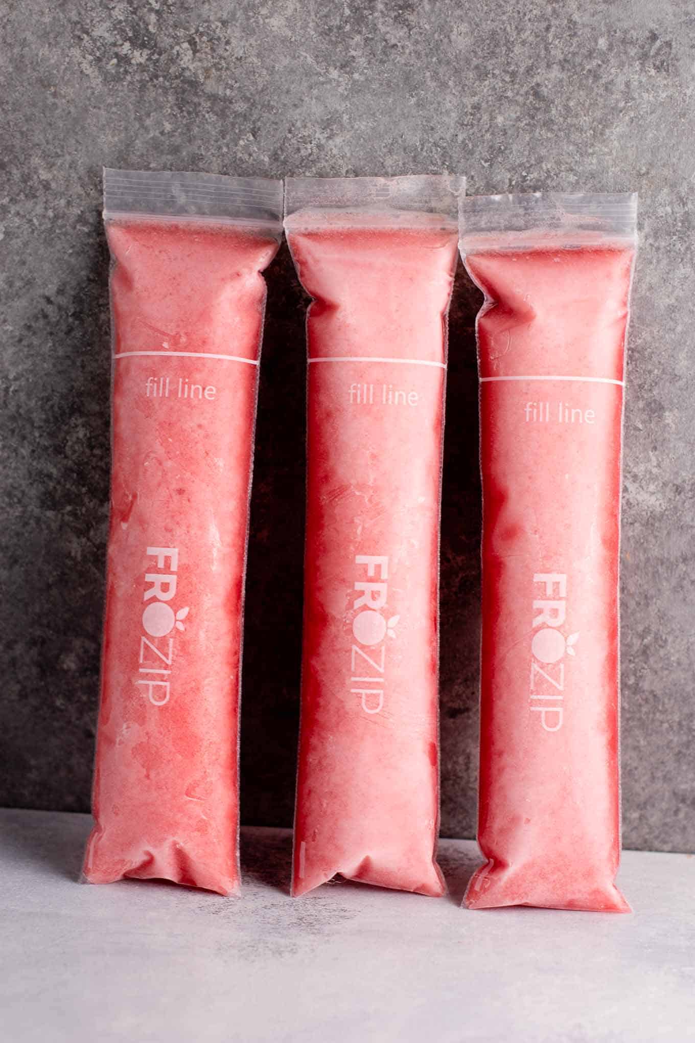 Strawberry pineapple freezer pops – learn how to make popsicles with just frozen fruit, coconut water and maple syrup! #freezerpops #healthy #icepops #popsicles #homemade #healthyrecipe #dessert #healthydessert #strawberrypineapple #summer