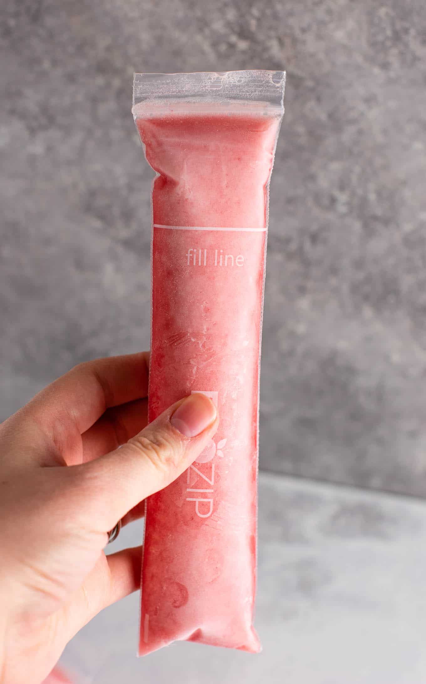 Strawberry pineapple freezer pops – learn how to make popsicles with just frozen fruit, coconut water and maple syrup! #freezerpops #healthy #icepops #popsicles #homemade #healthyrecipe #dessert #healthydessert #strawberrypineapple #summer