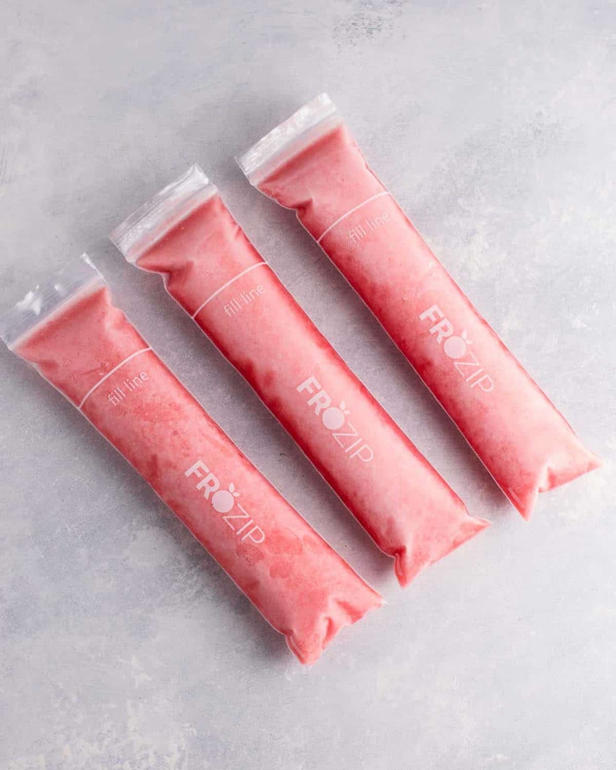 Strawberry pineapple freezer pops – learn how to make popsicles with just frozen fruit, coconut water and maple syrup! #freezerpops #healthy #icepops #popsicles #homemade #healthyrecipe #dessert #healthydessert #strawberrypineapple #summer