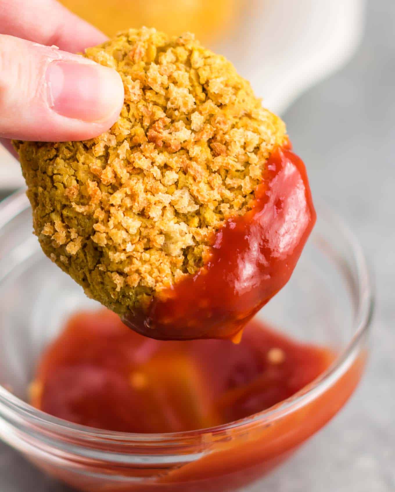 vegetarian chickpea nugget being dipped in ketchup