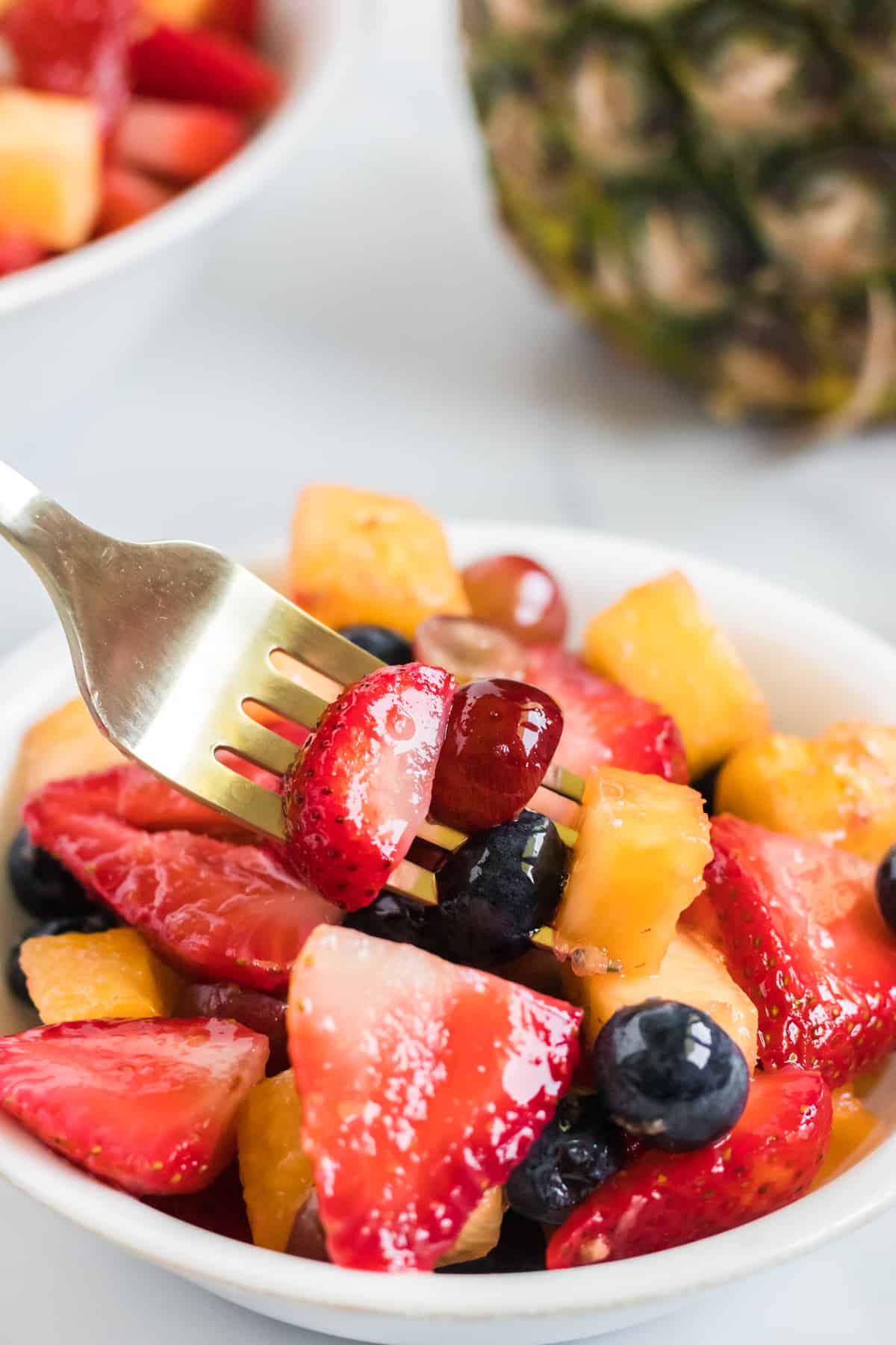 a fork taking a bite of fruit salad