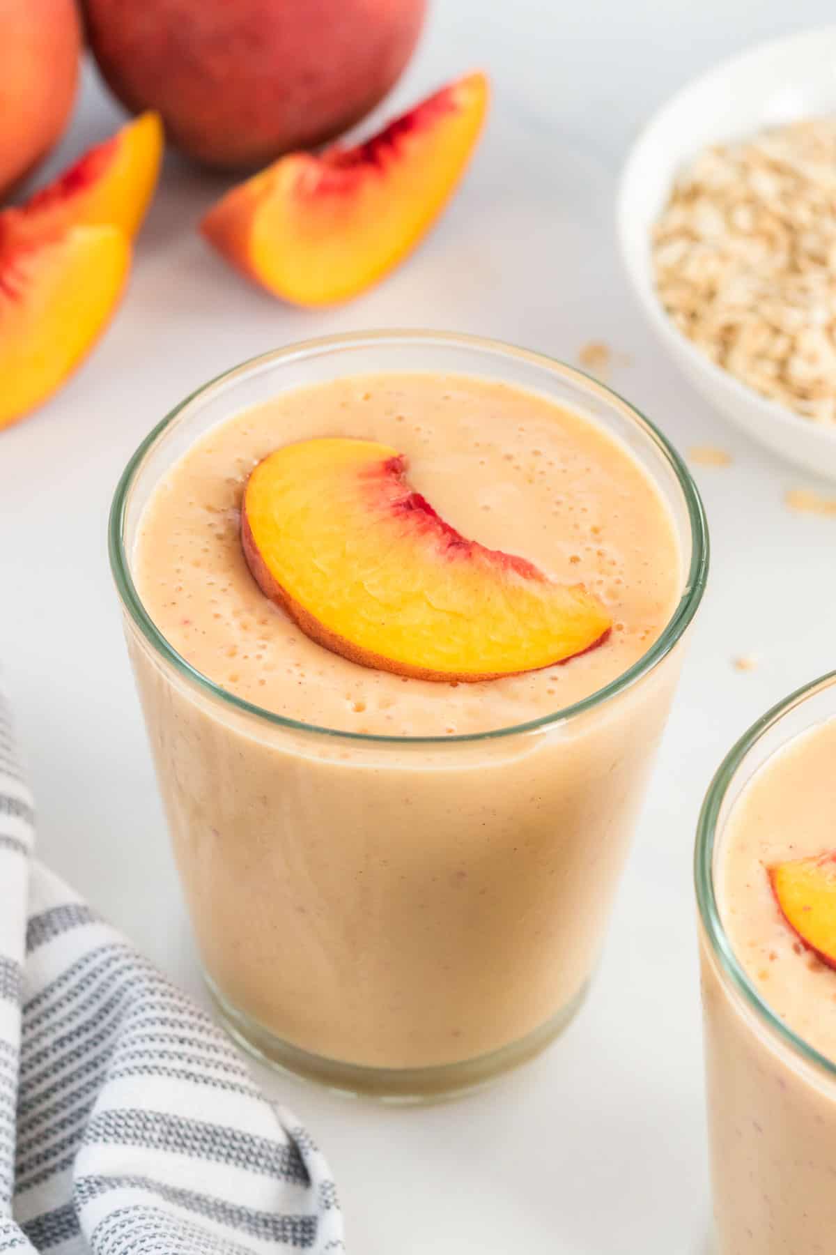 peach smoothie glass with a sliced peach on top