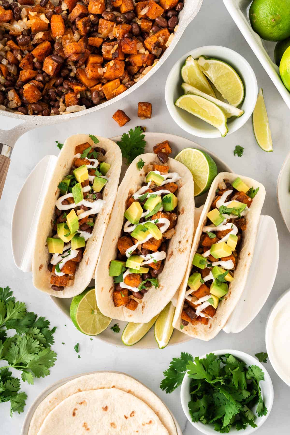 sweet potato tacos topped with sour cream and diced avocado