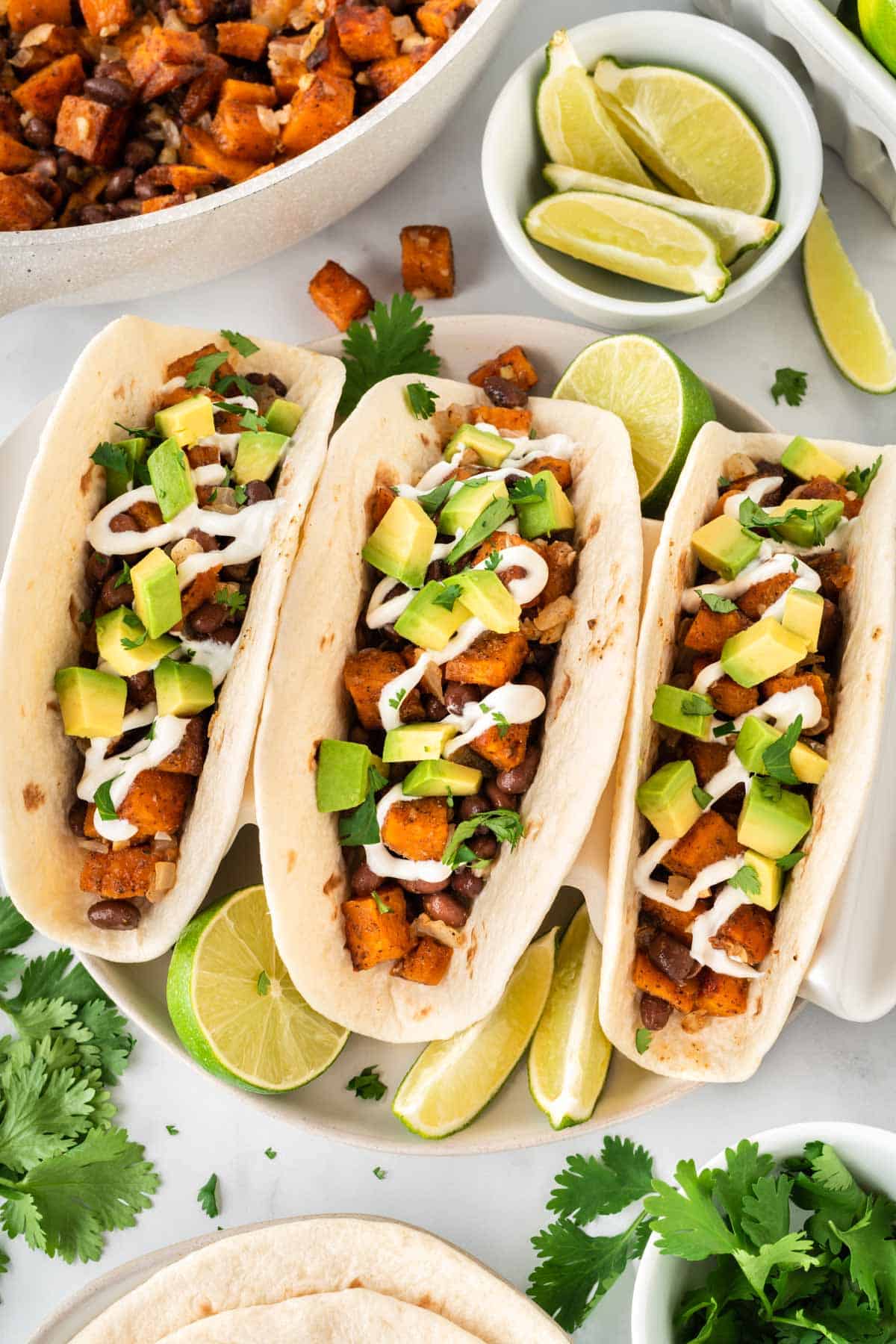 sweet potato tacos topped with sour cream and diced avocado