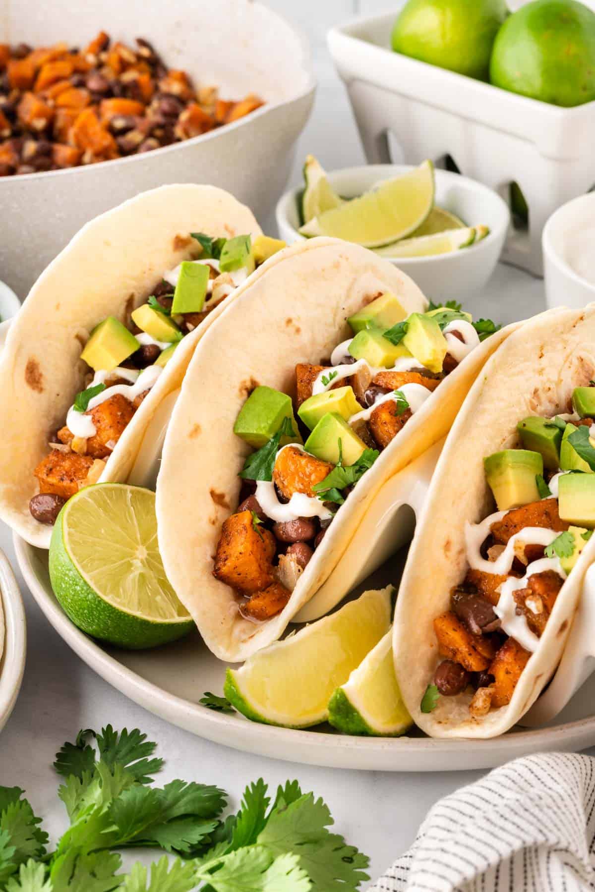 sweet potato tacos topped with sour cream and diced avocado