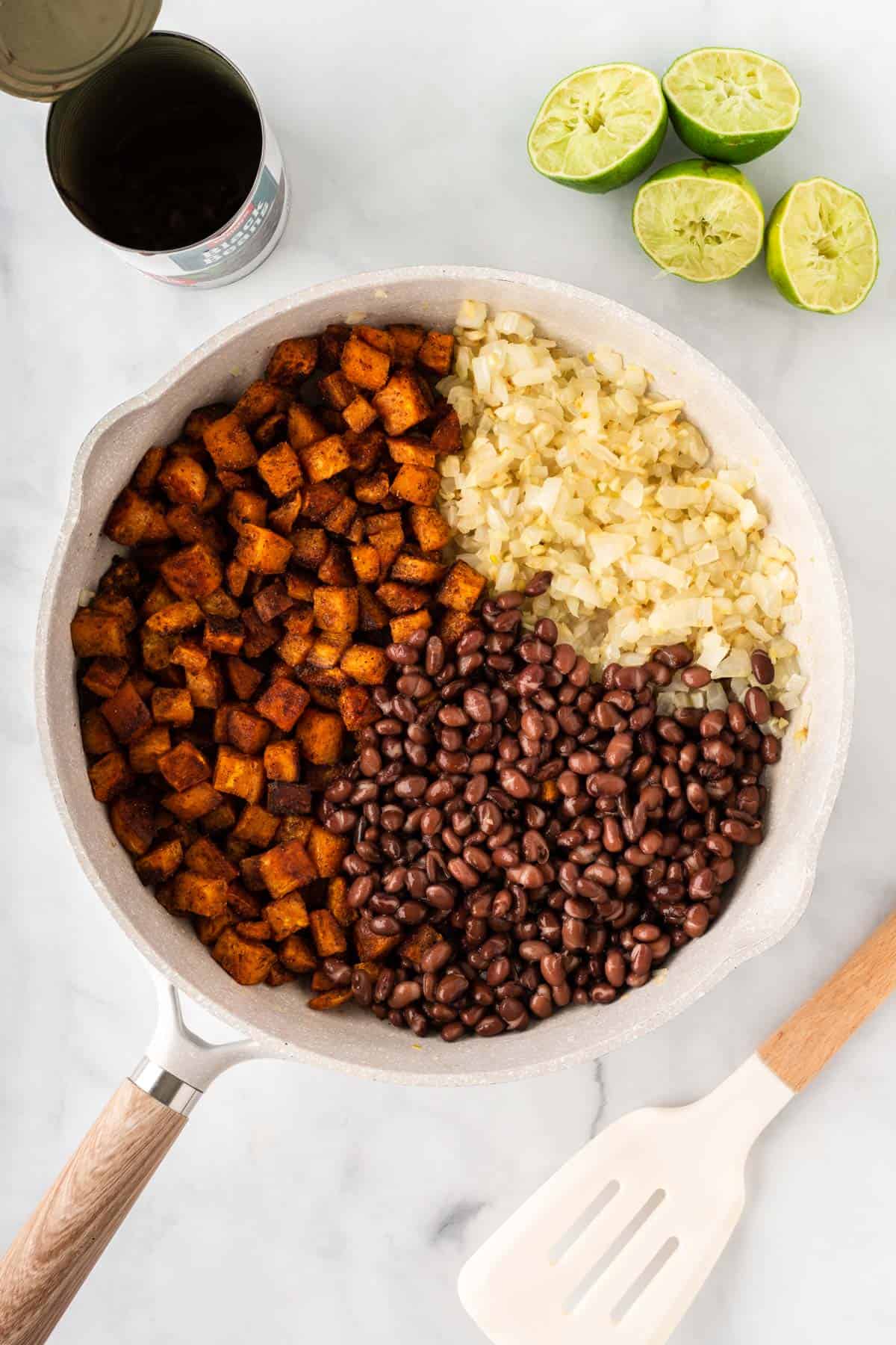 adding the sweet potatoes and black beans to the skillet
