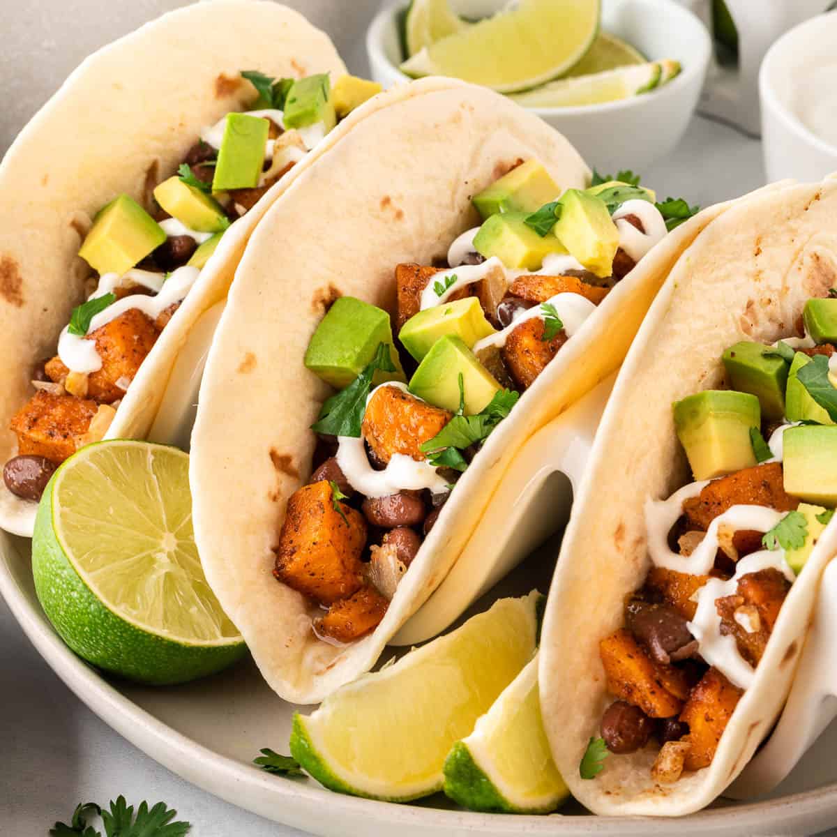sweet potato tacos topped with sour cream and diced avocado