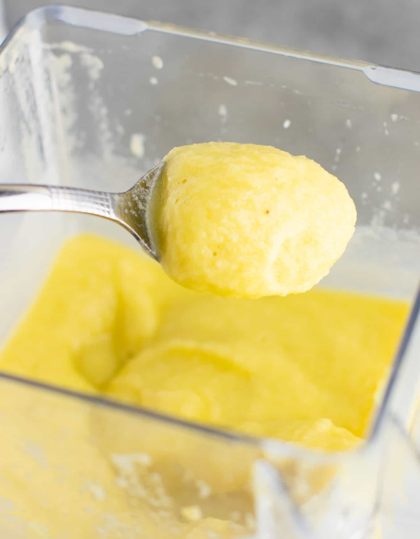 smoothie in the blender with a spoon taking a bite out