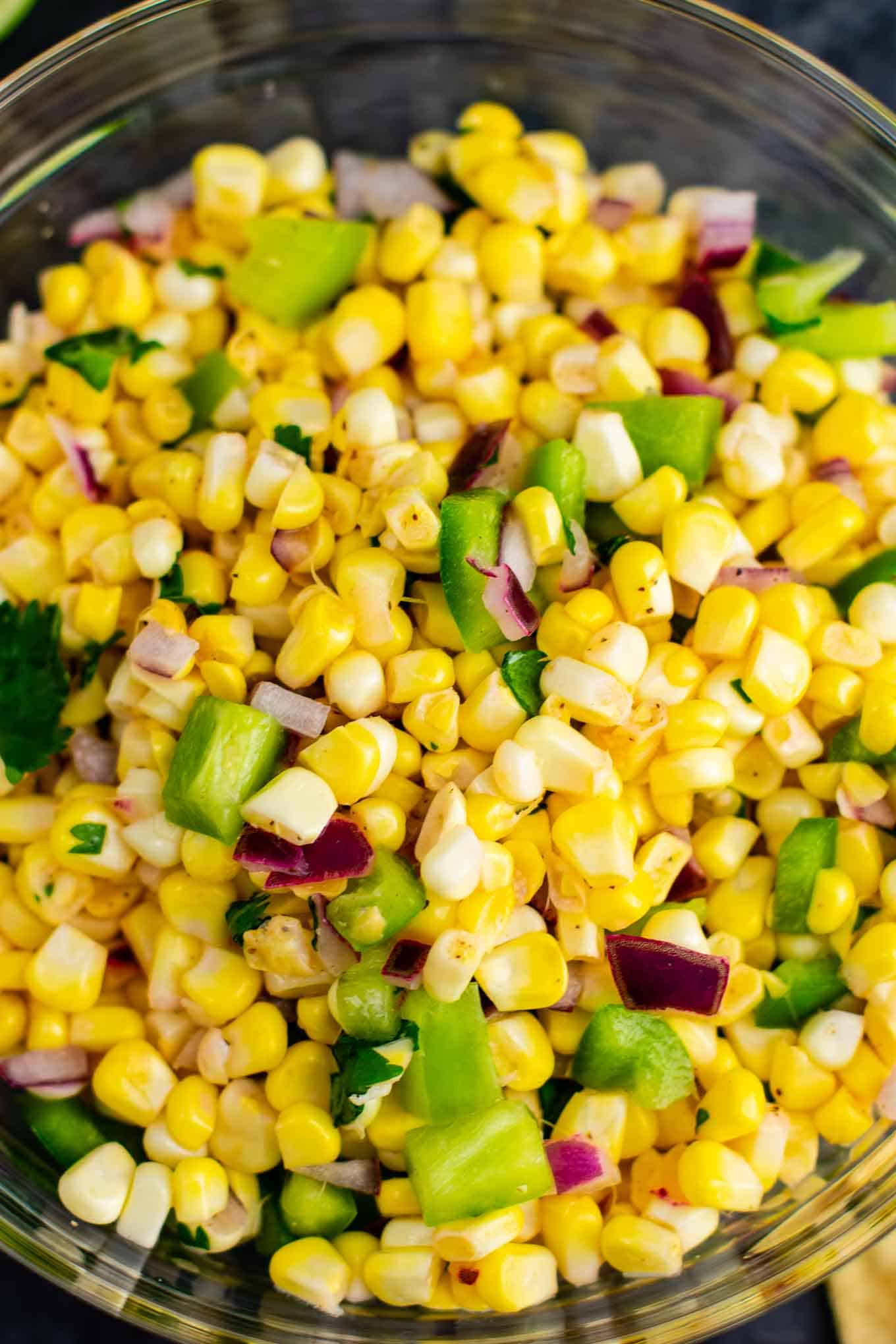 The best easy fresh corn salsa recipe made with just a few ingredients. It tastes better than chipotle and is ready in minutes! Make your own burrito bowls at home with this awesome corn salsa. #chipotlecornsalsa #cornsalsa #chipotle #burritobowl #appetizer #vegan #corn #appetizer