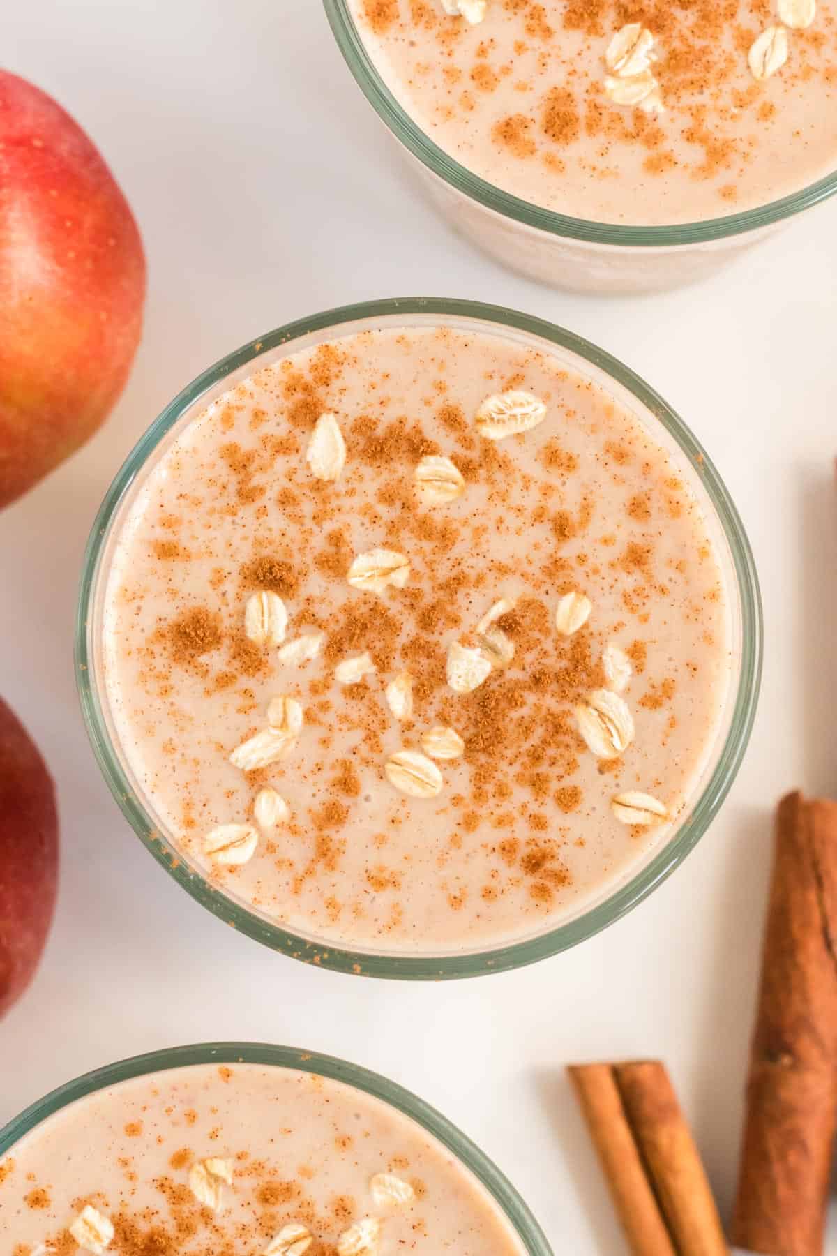 glass full of healthy apple pie smoothie topped with cinnamon and oats