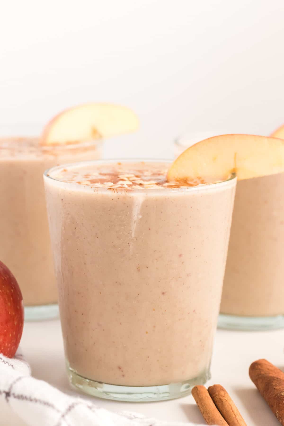 glass full of healthy apple pie smoothie topped with cinnamon and oats