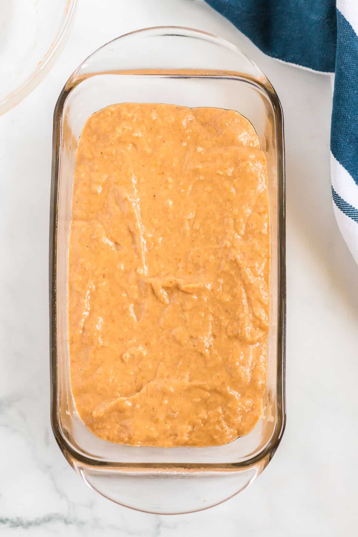 banana bread batter spread into a loaf pan
