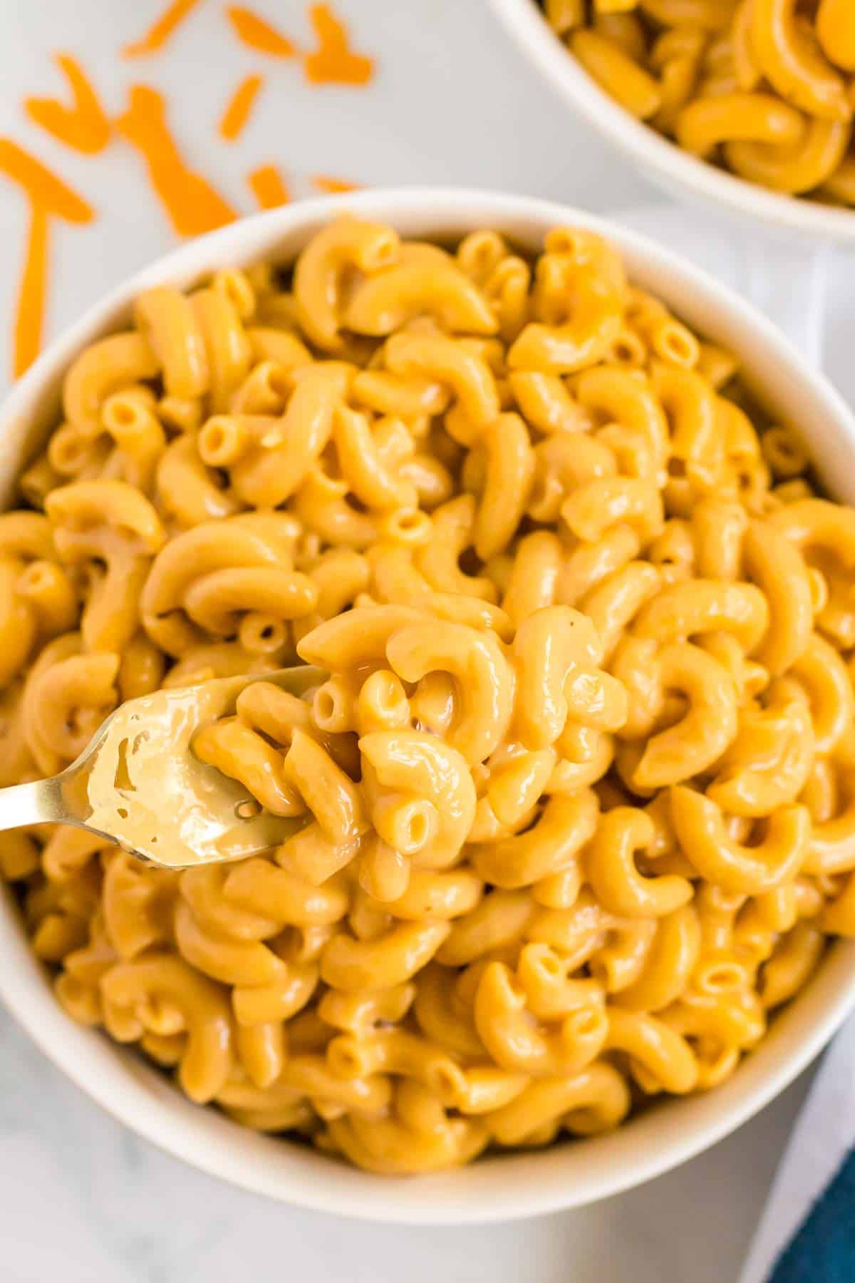 mac and cheese in a white bowl with a fork