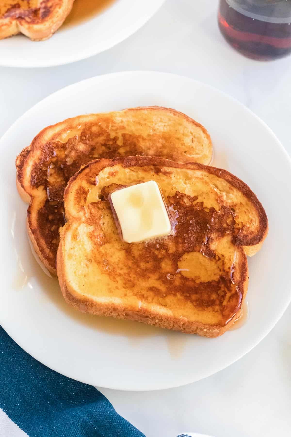 eggnog french toast on a plate topped with butter and maple syrup