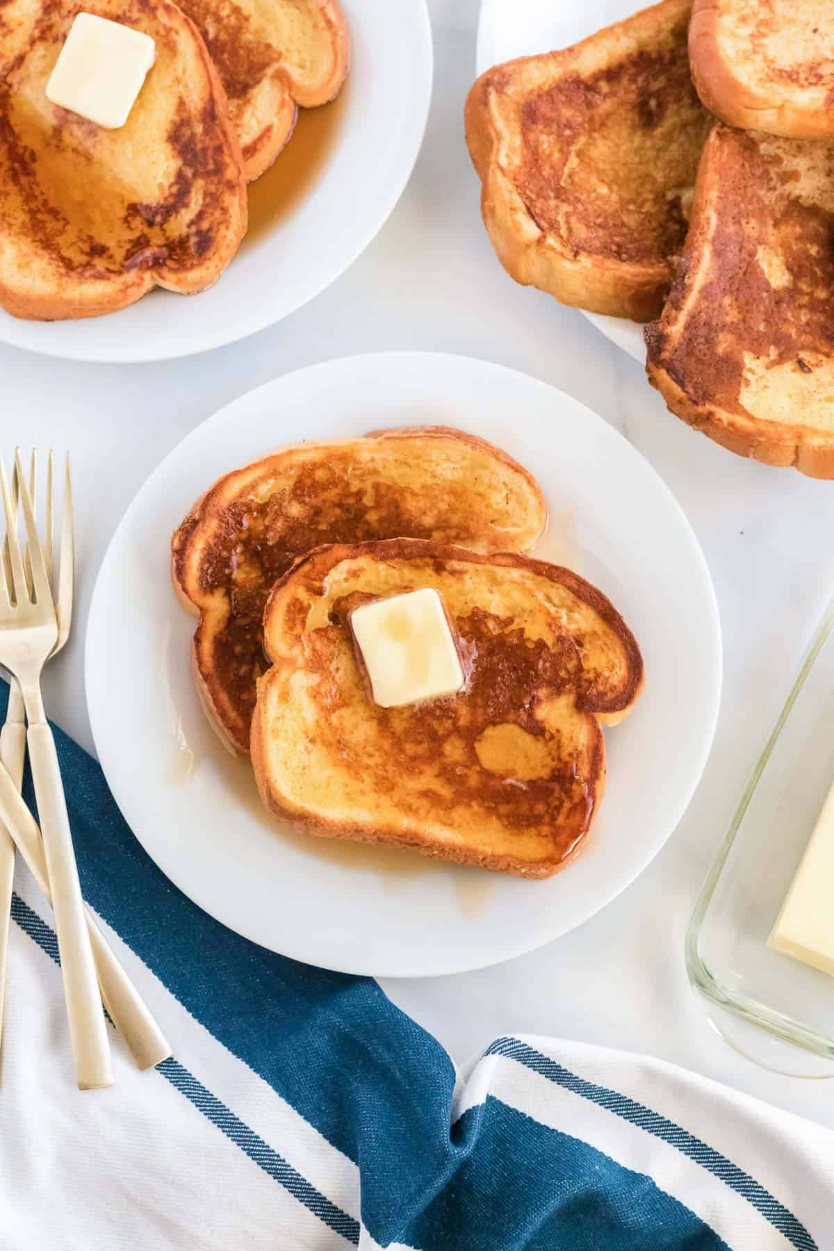 eggnog french toast on a plate topped with butter and maple syrup