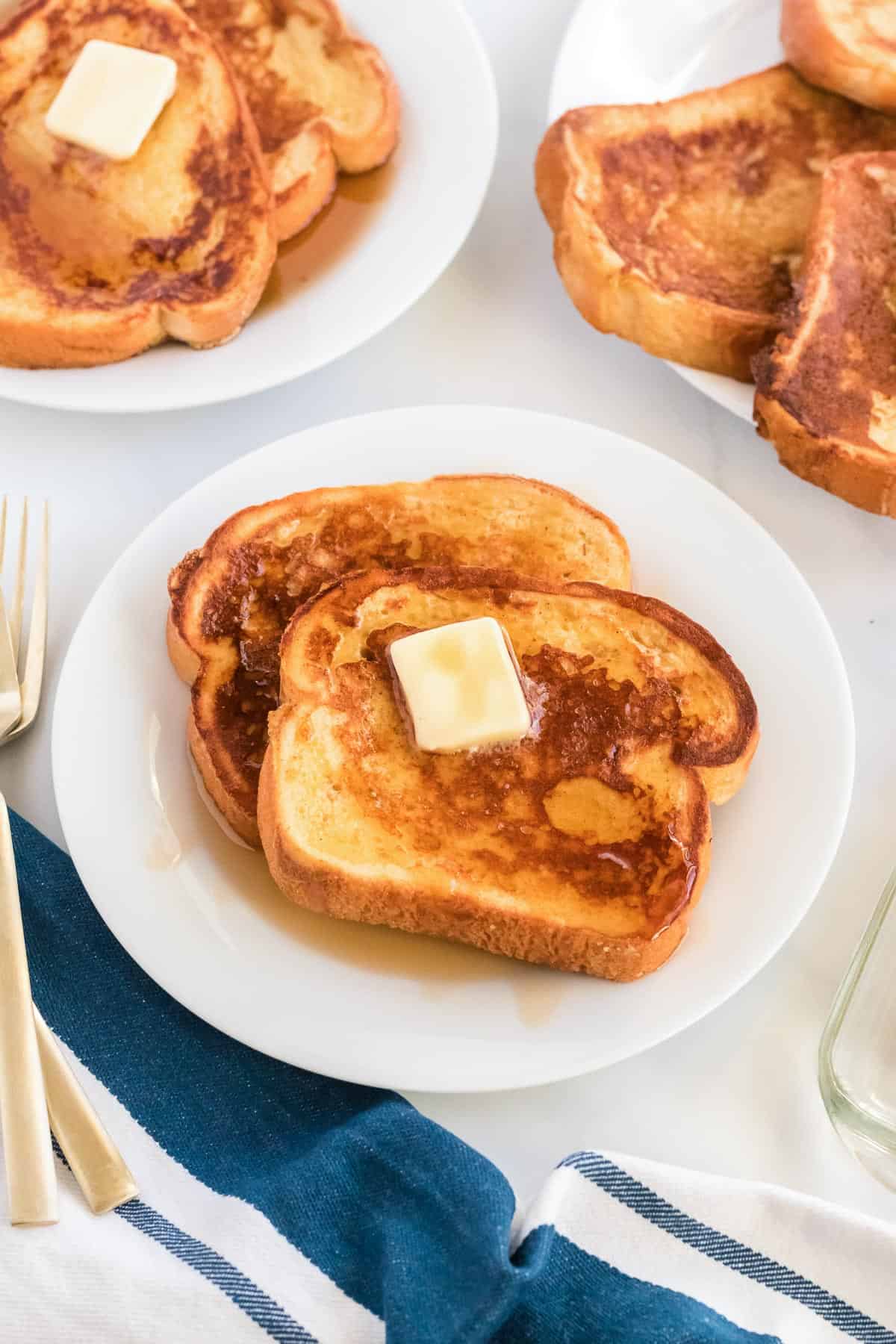 eggnog french toast on a plate topped with butter and maple syrup