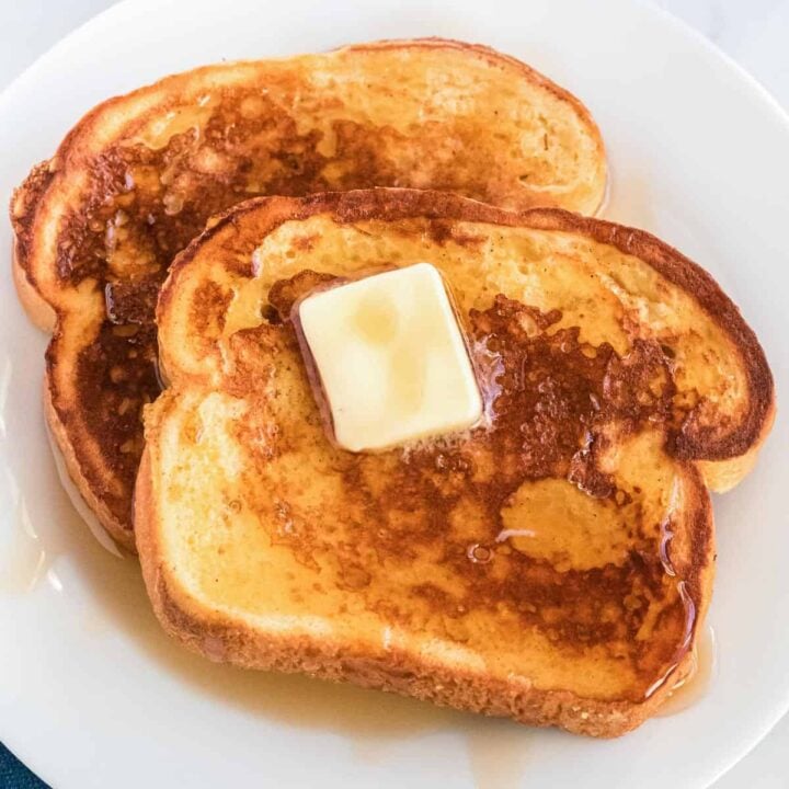 eggnog french toast on a plate topped with butter and maple syrup