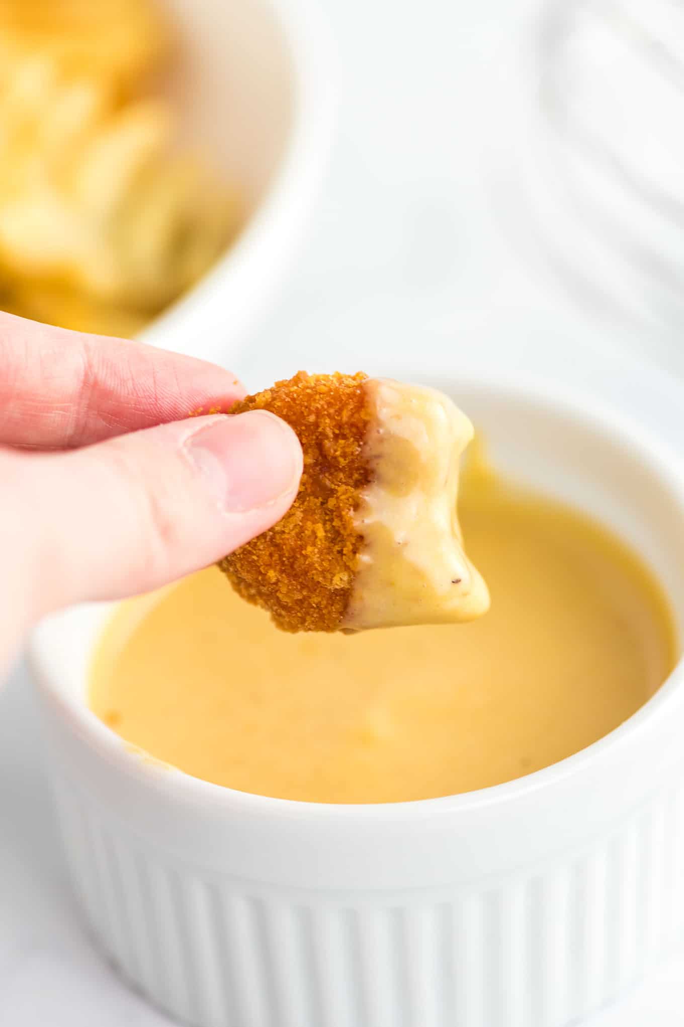 chicken nugget dipped in chick fil a sauce with a bite taken out