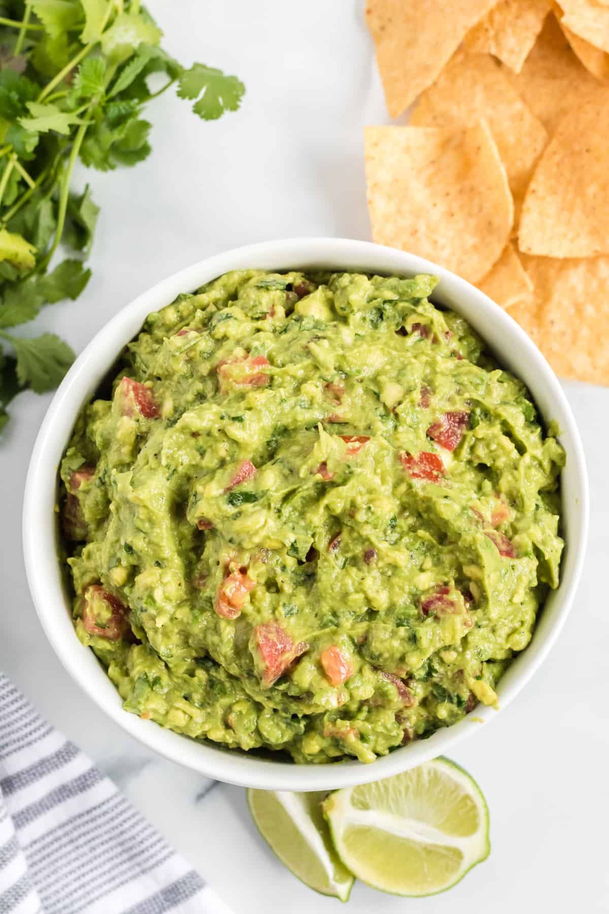 guacamole with tomatoes in a white bowl