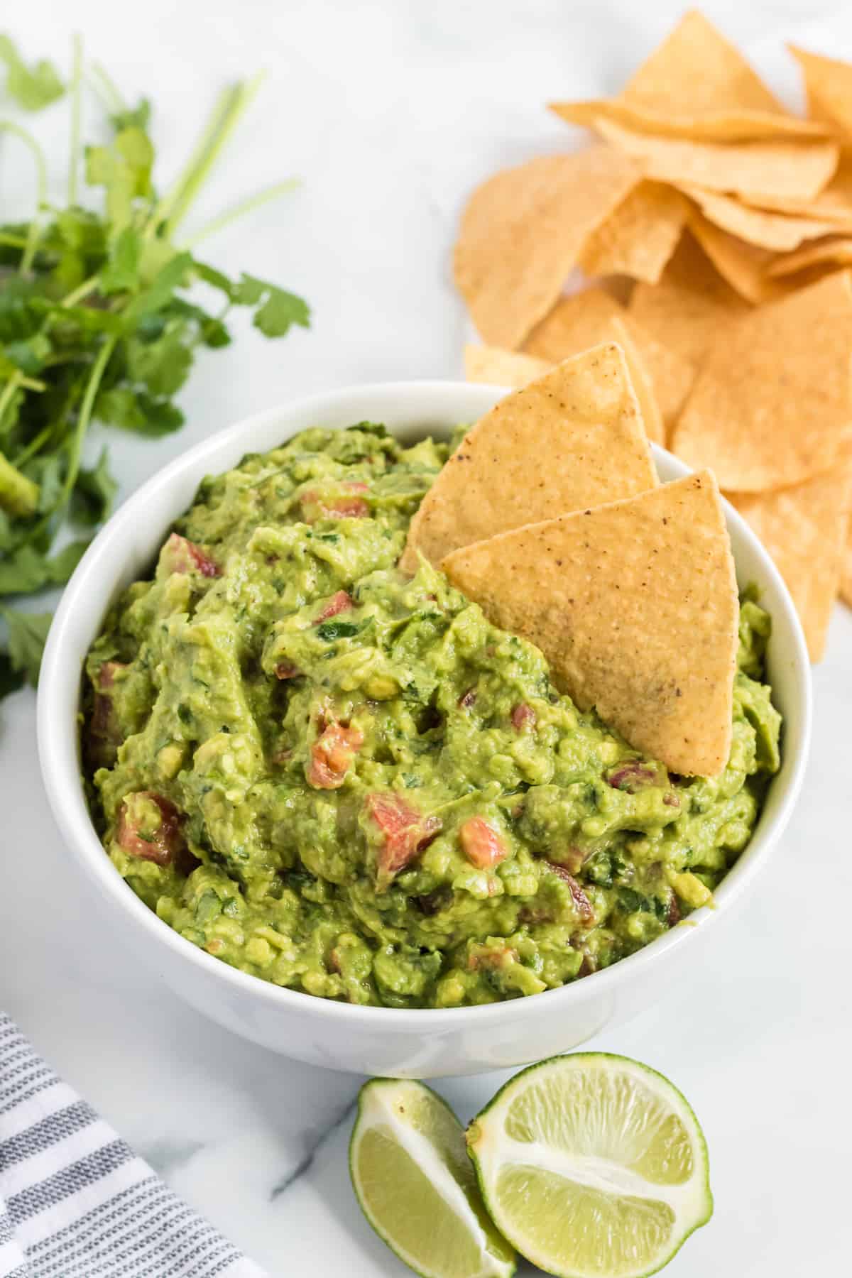 guacamole in a bowl with tortilla chips dipped in it