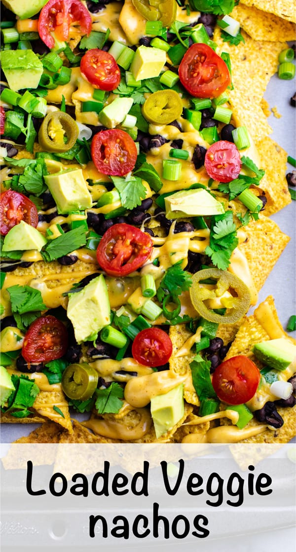 Loaded veggie nachos topped with homemade nacho cheese sauce. These are amazing! #veggienachos #vegetarian #nachocheese #nachocheesesauce