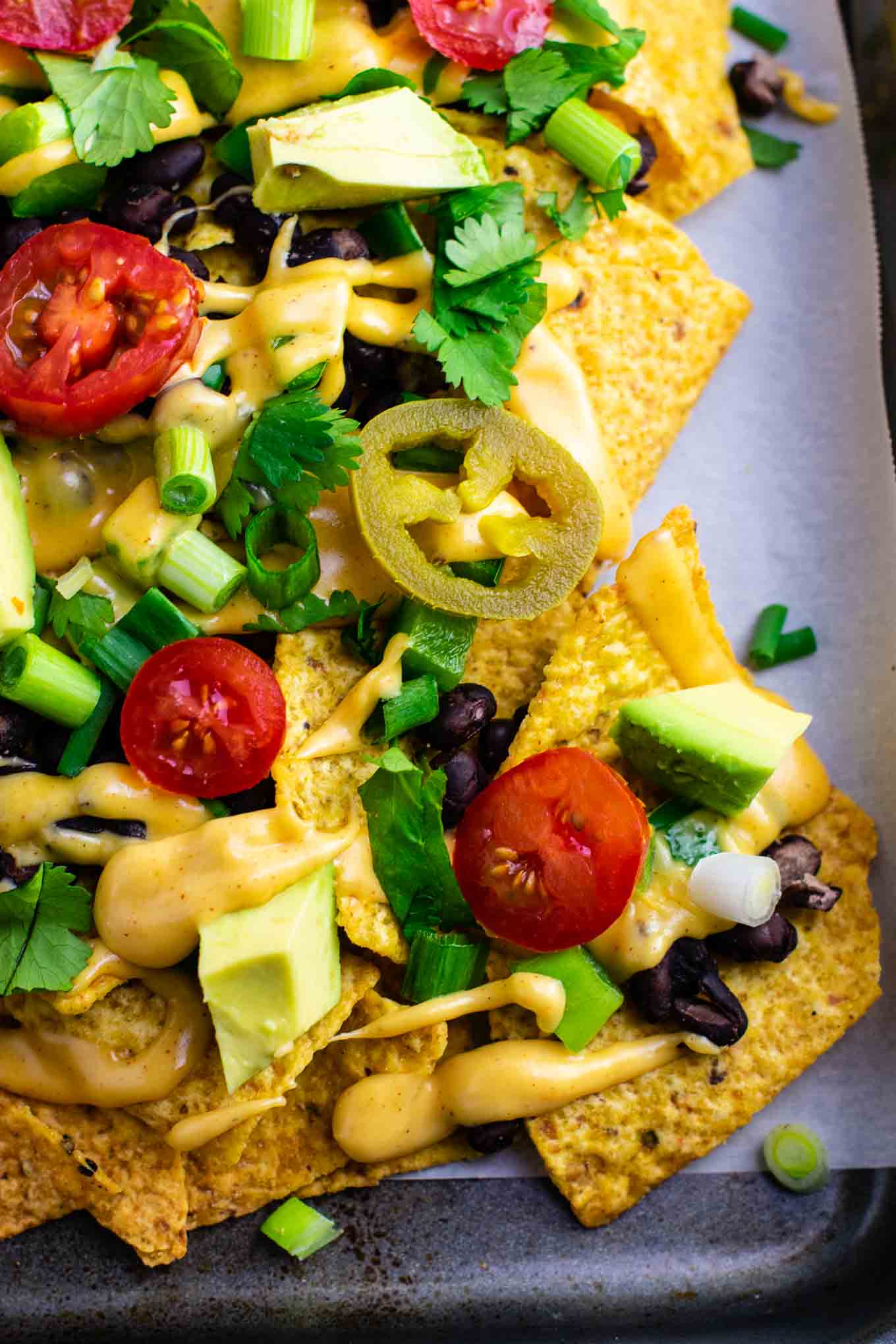 Loaded veggie nachos topped with homemade nacho cheese sauce. These are amazing! #veggienachos #vegetarian #nachocheese #nachocheesesauce