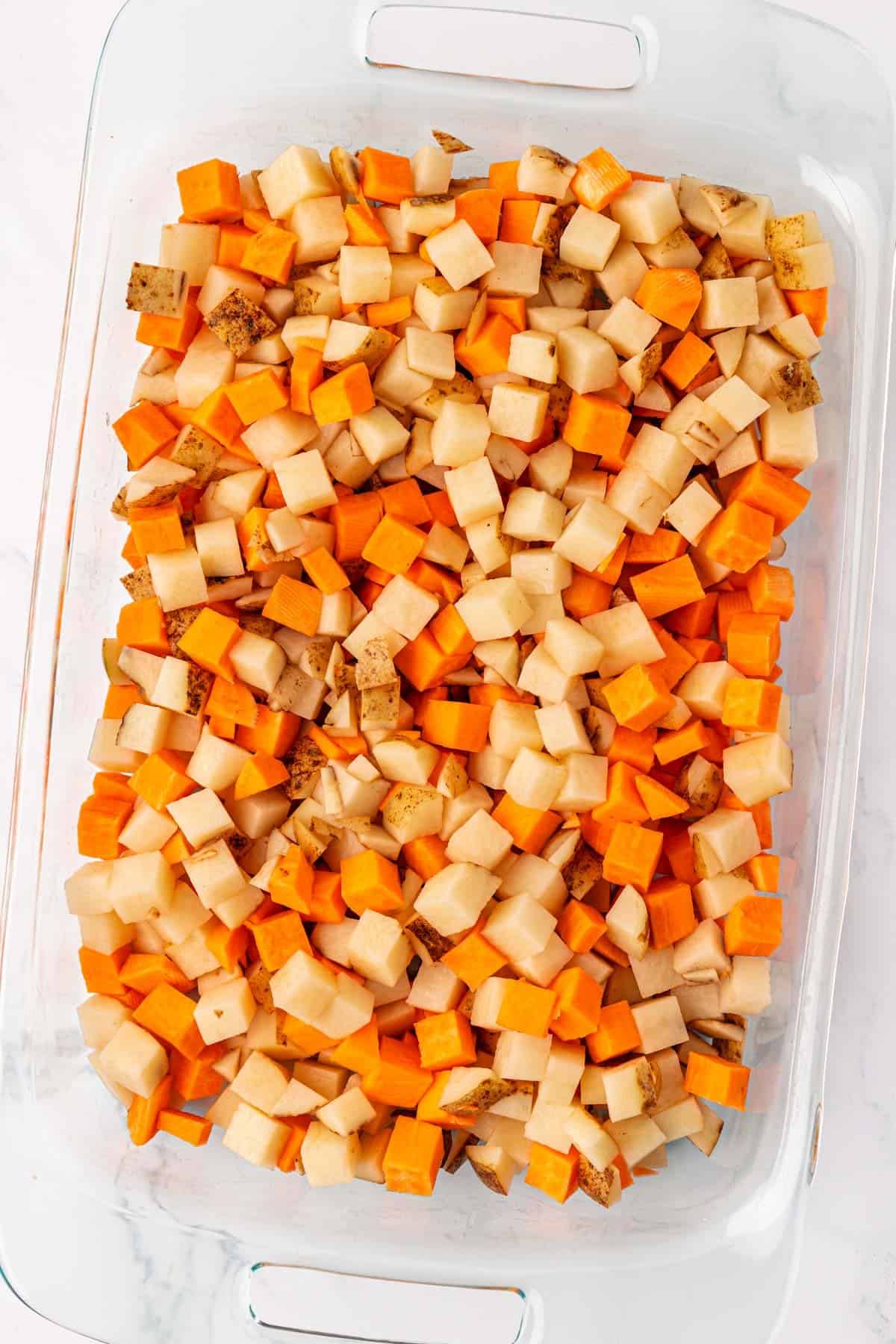 russet and sweet potatoes in a baking dish