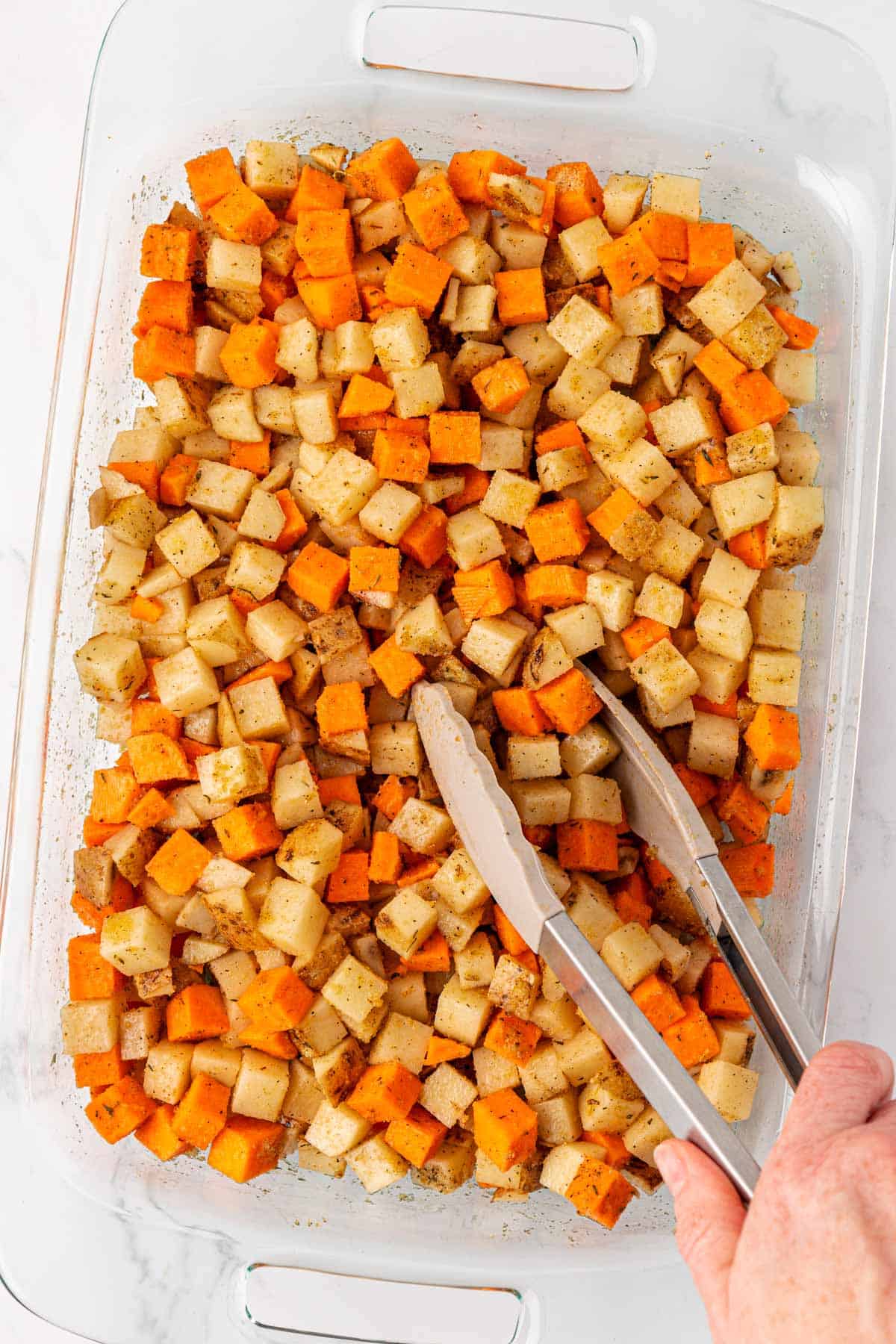 mixing the spices and olive oil into the potatoes