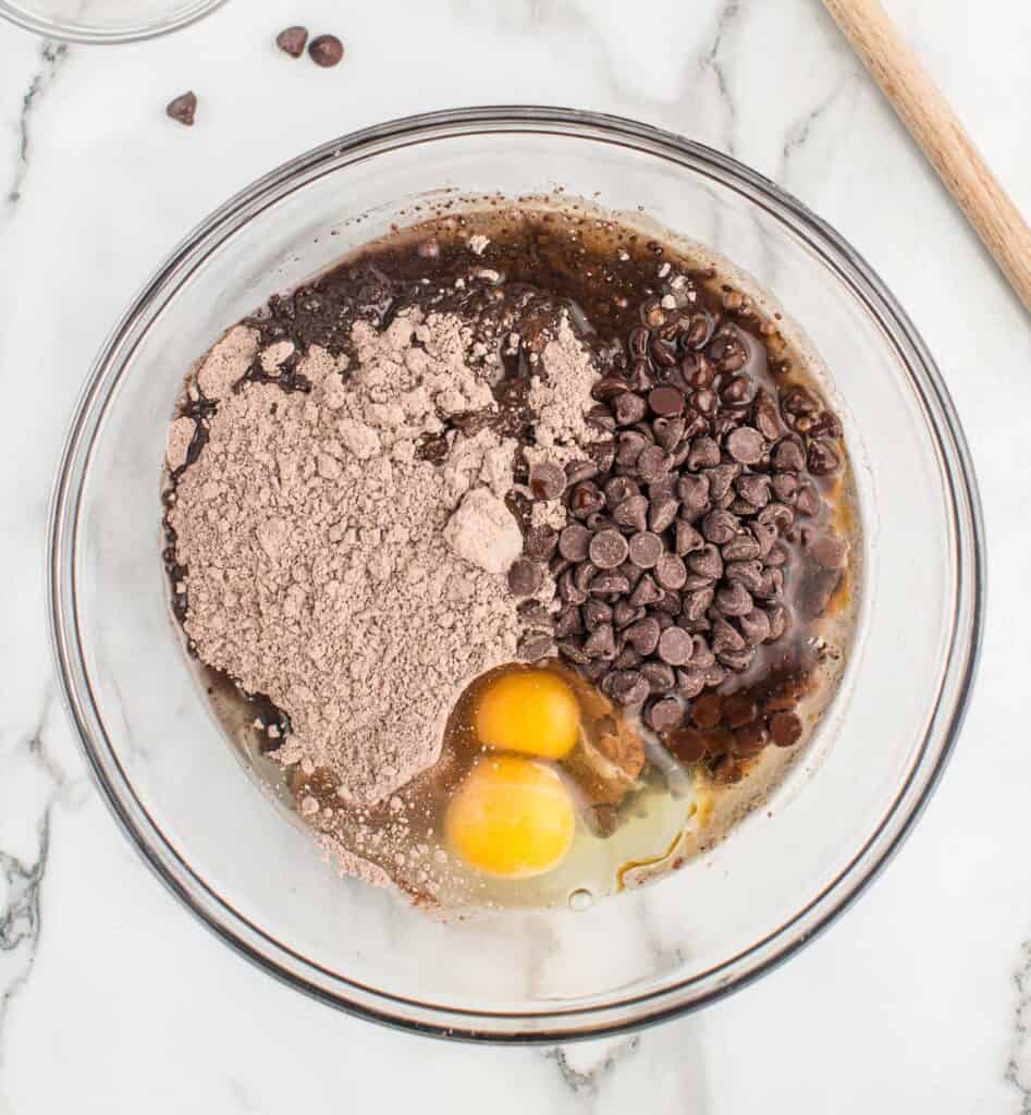 eggs, oil, chocolate cake mix, and chocolate chips in a mixing bowl