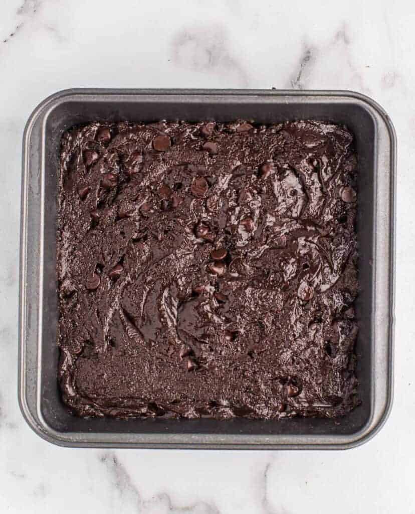 brownie batter spread out in an 8 by 8 baking dish