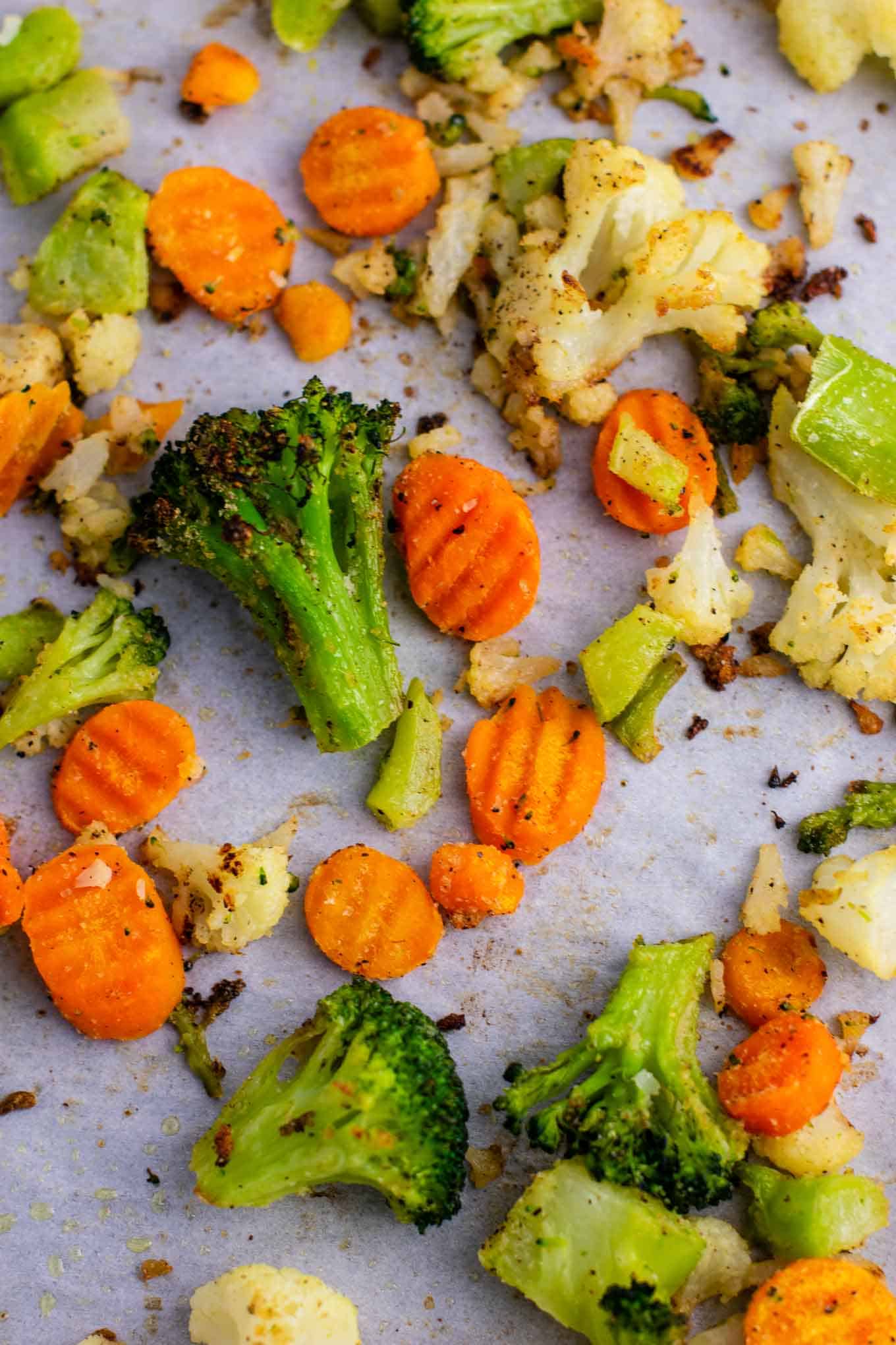 Roasted carrots, cauliflower, and broccoli on a baking sheet