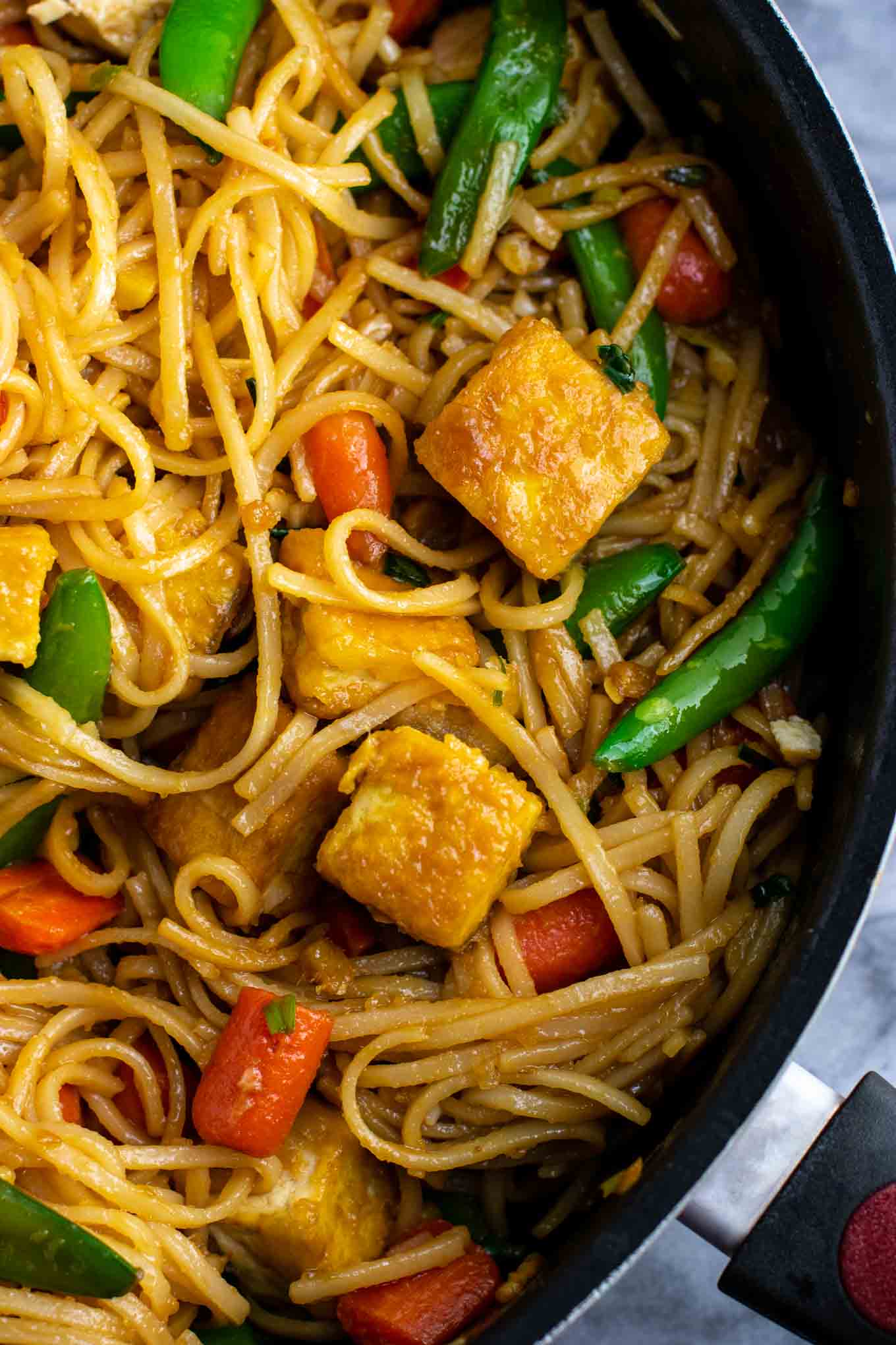 Vegan stir fry noodles with sugar snap peas and carrots. Homemade 3 ingredient stir fry sauce makes this taste amazing! #tofu #stirfrynoodles #stirfry #vegan #dinner #stirfryrecipe #vegetarian #tofustirfy