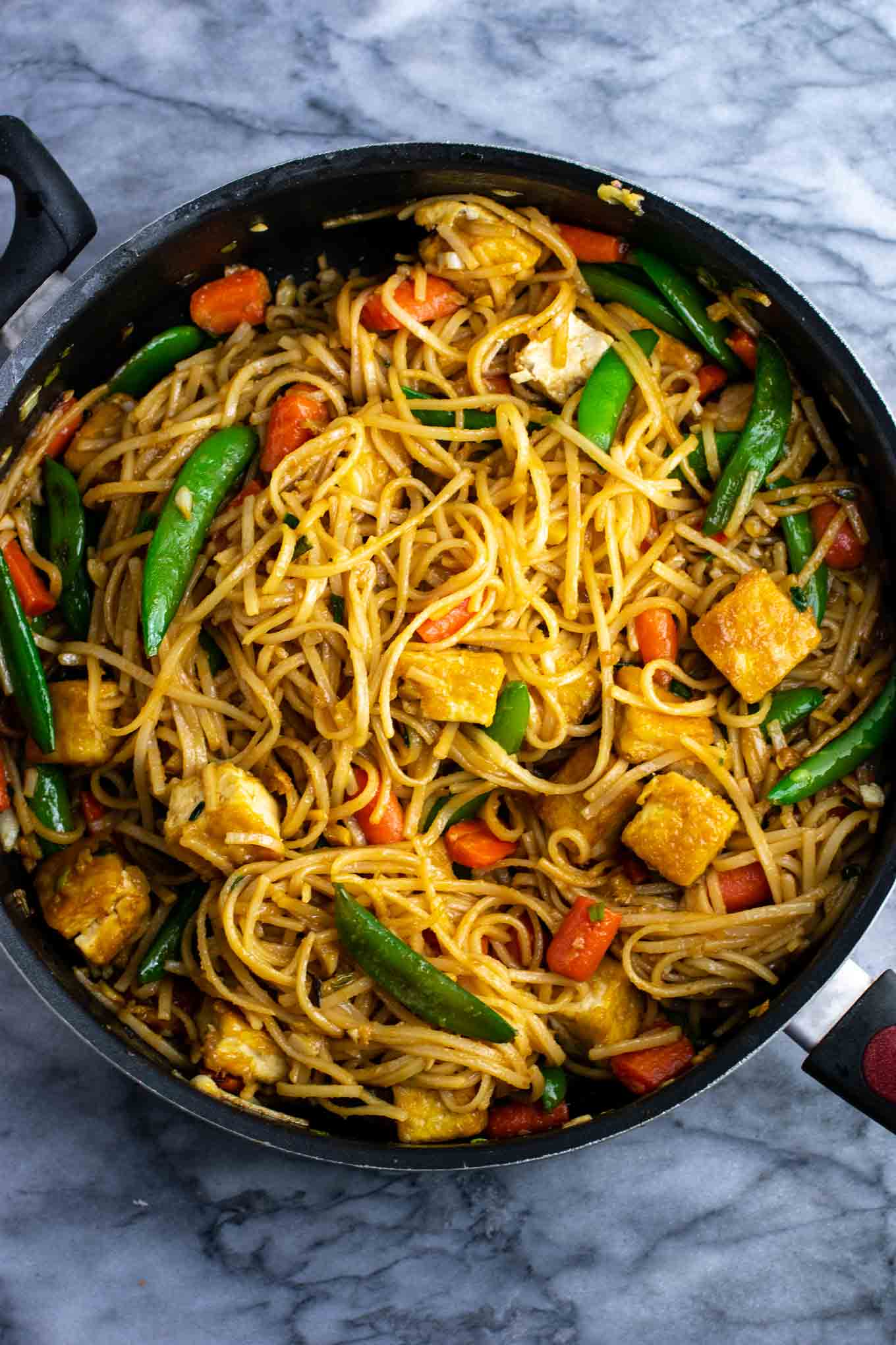 Vegan stir fry noodles with sugar snap peas and carrots. Homemade 3 ingredient stir fry sauce makes this taste amazing! #tofu #stirfrynoodles #stirfry #vegan #dinner #stirfryrecipe #vegetarian #tofustirfy