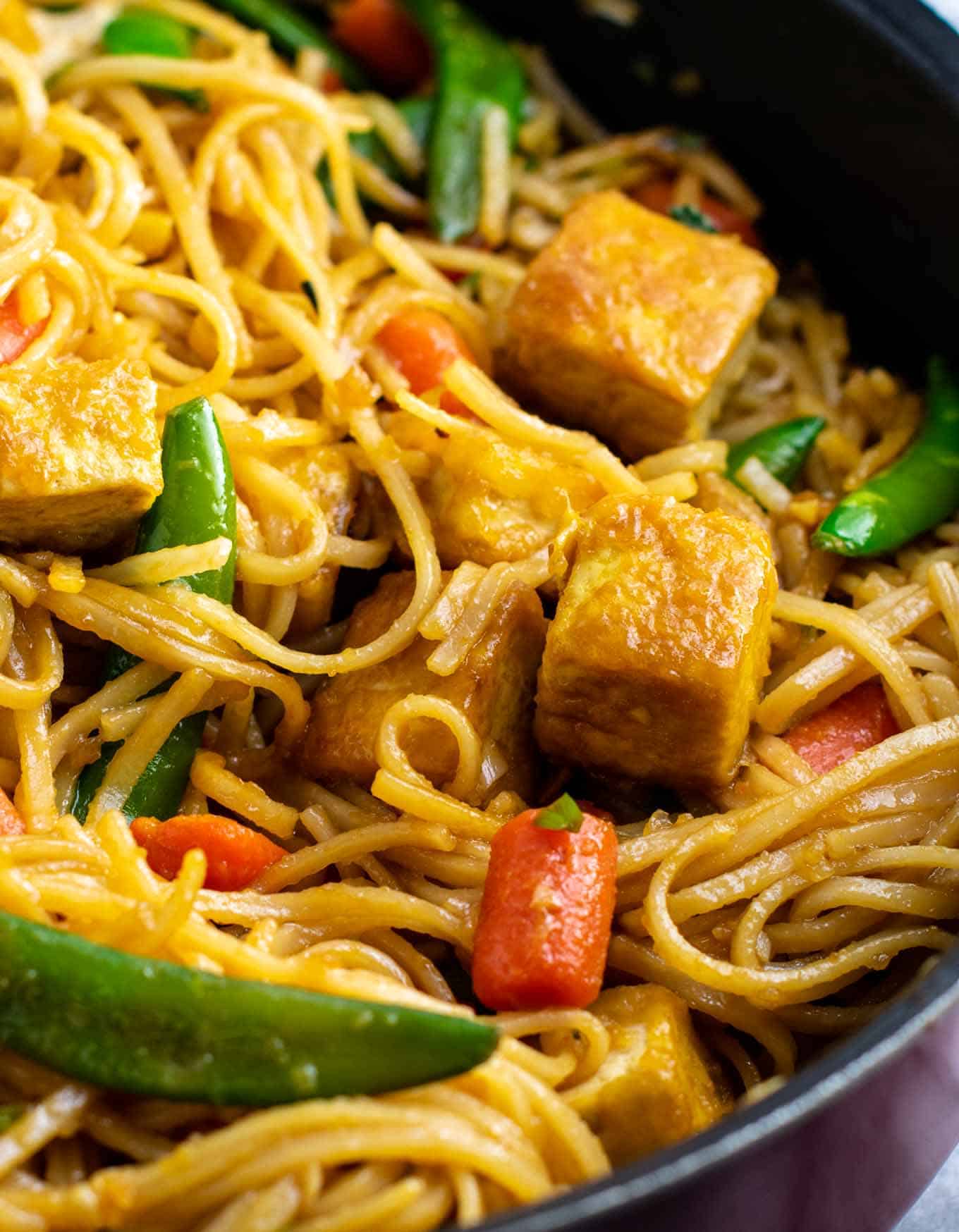 Vegan stir fry noodles with sugar snap peas and carrots. Homemade 3 ingredient stir fry sauce makes this taste amazing! #tofu #stirfrynoodles #stirfry #vegan #dinner #stirfryrecipe #vegetarian #tofustirfy