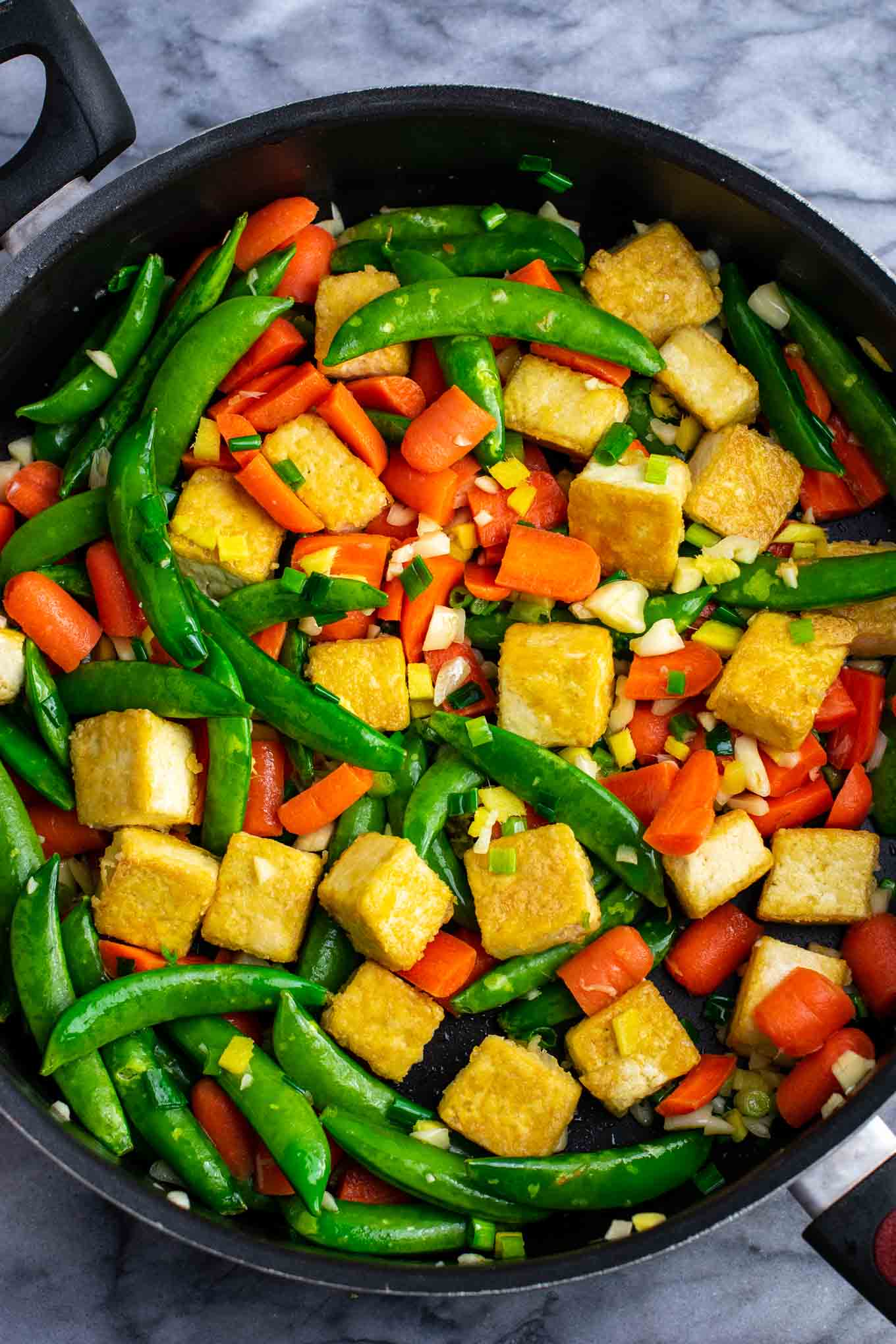 Tofu stir fry noodles with sugar snap peas and carrots. Homemade 3 ingredient stir fry sauce makes this taste amazing! #tofu #stirfrynoodles #stirfry #vegan #dinner #stirfryrecipe #vegetarian #tofustirfy