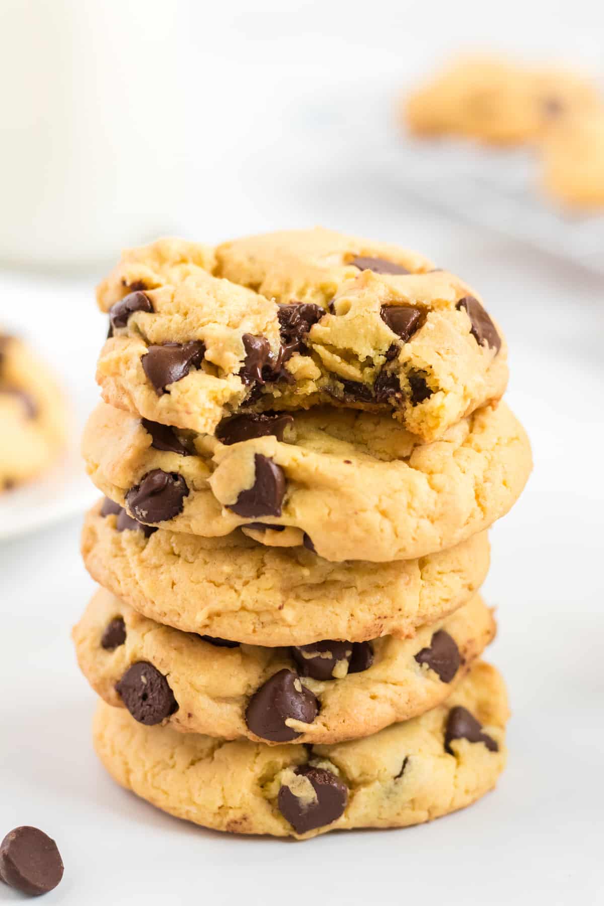 a stack of yellow cake mix cookies with the top one taken a bite out of