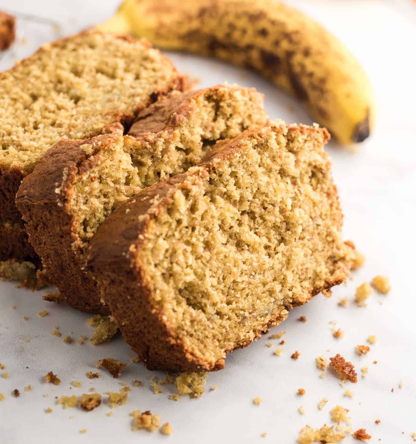 banana bread sliced with a banana in the background