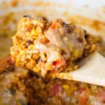 taking a scoop of mexican rice casserole from the dish