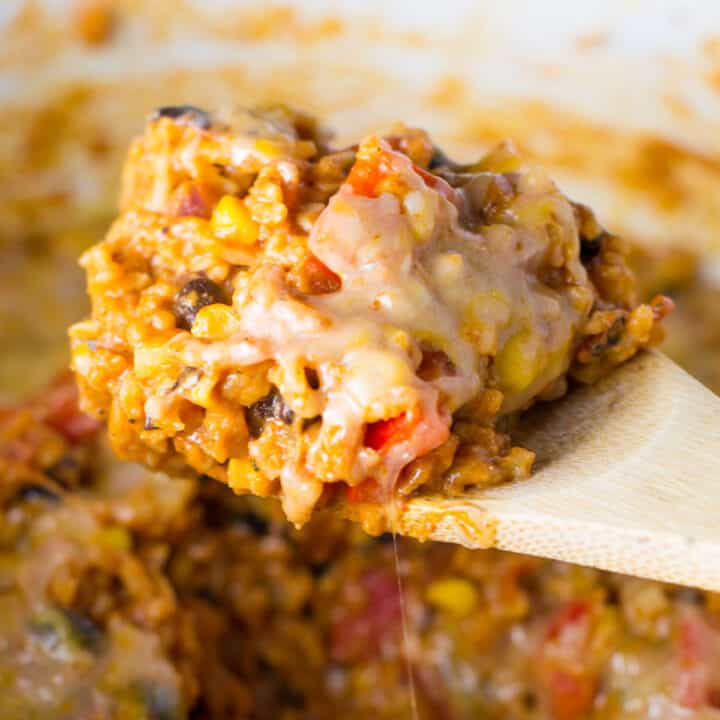 taking a scoop of mexican rice casserole from the dish