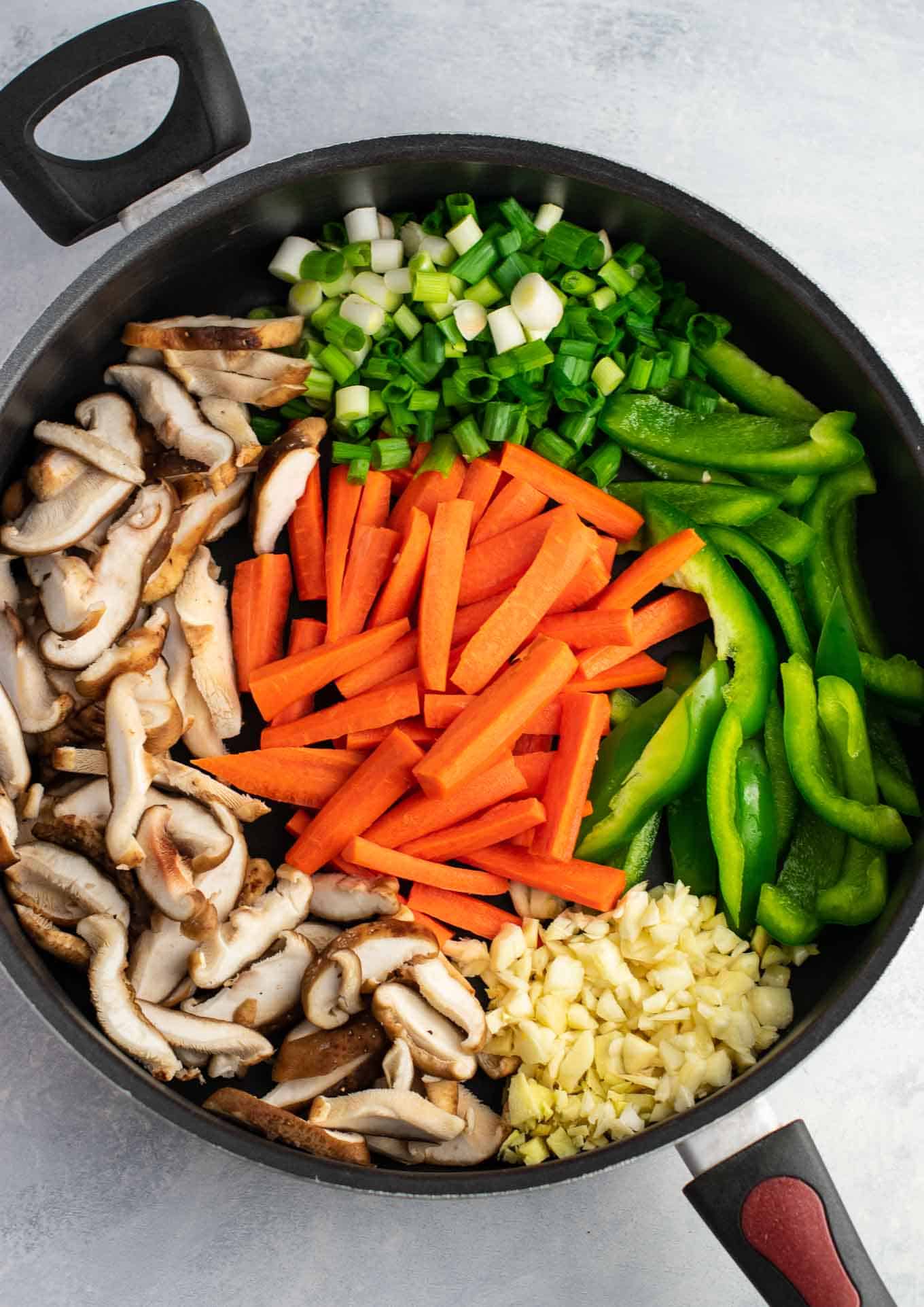 golden oak shitake mushrooms, sugar snap peas, green bell pepper, carrots, green onions, and fresh garlic and ginger in a skillet