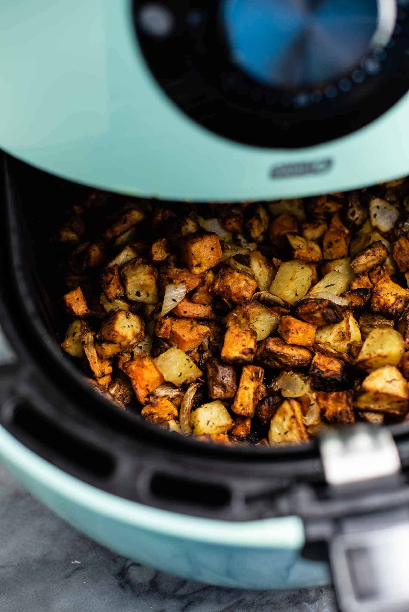 hash in an air fryer basket being pulled out