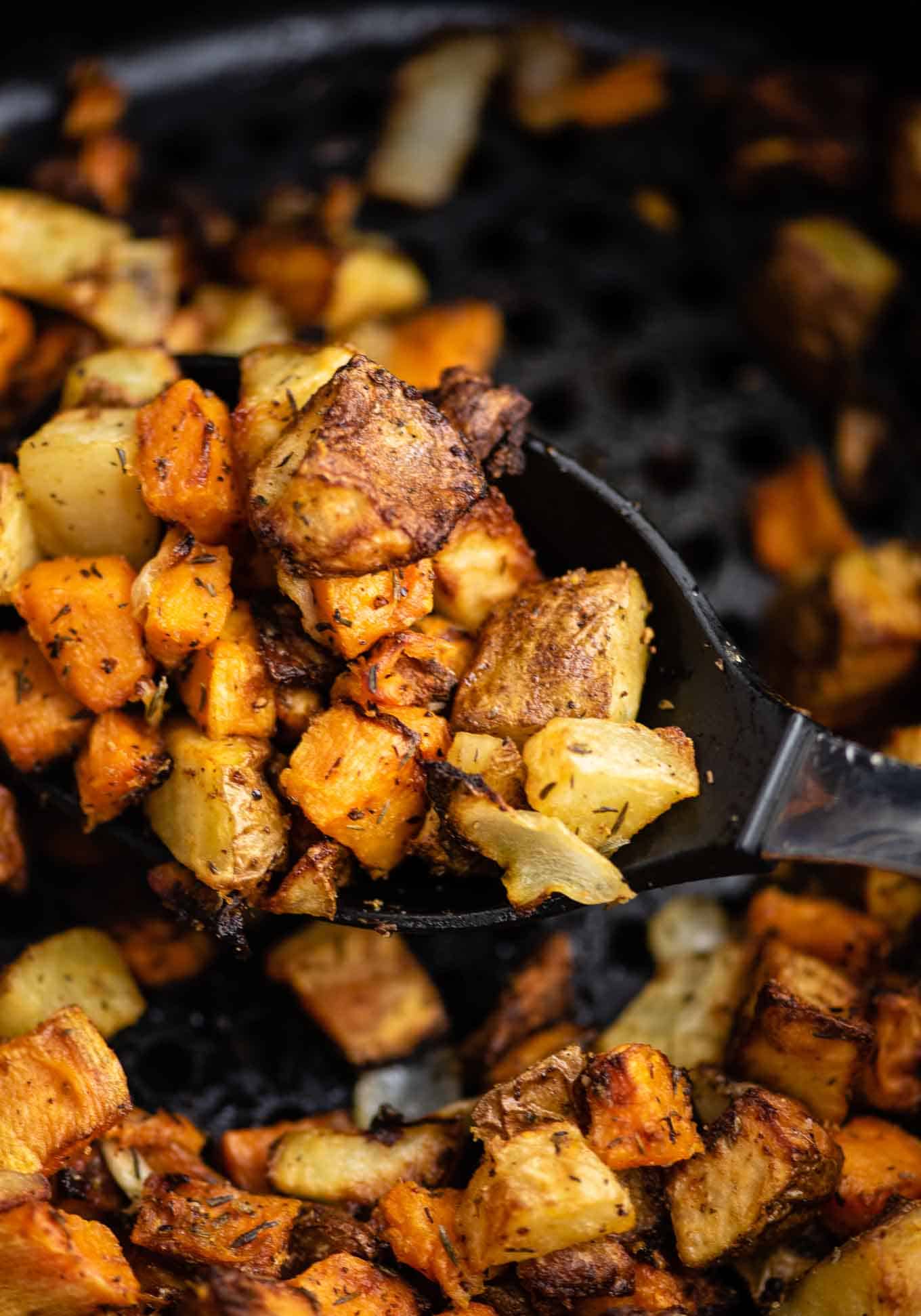 air fryer sweet potatoes and russet potatoes on the serving spoon