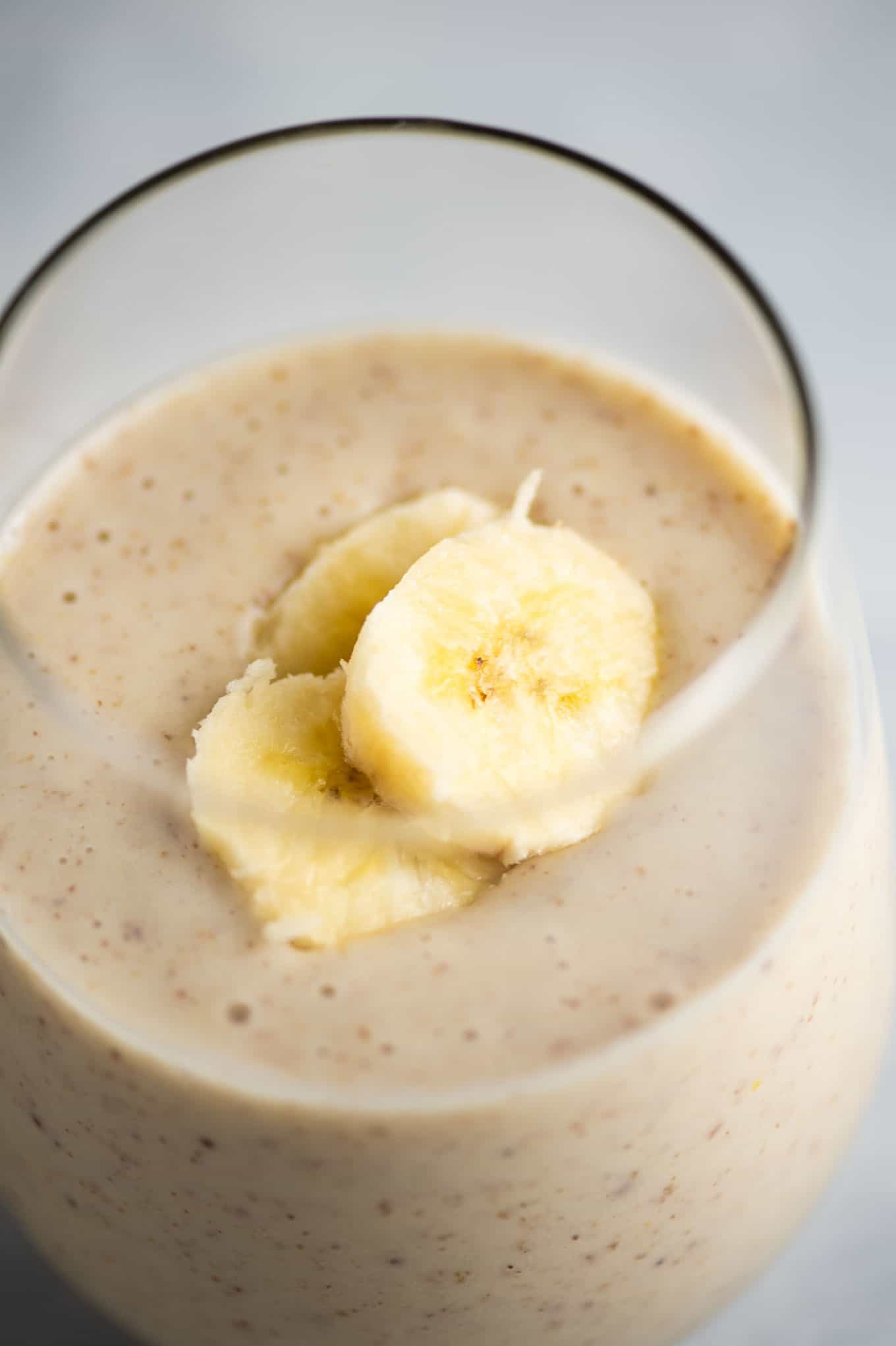 banana smoothie in a glass with sliced banana