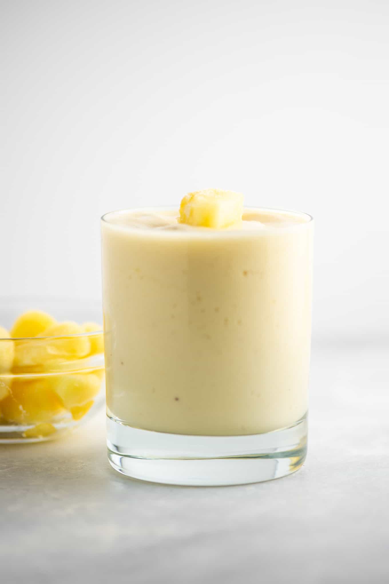 smoothie in a glass with pineapple in the background