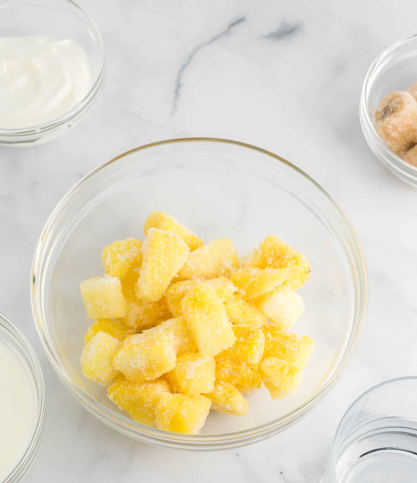 frozen pineapple chunks in a clear glass bowl